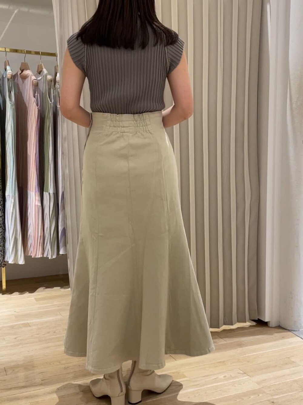 ベージュ系のデニムジャケット、ベージュ系のスカート、ベージュ系のニット/セーターを着用したレディースの夏コーディネートの6枚目の写真