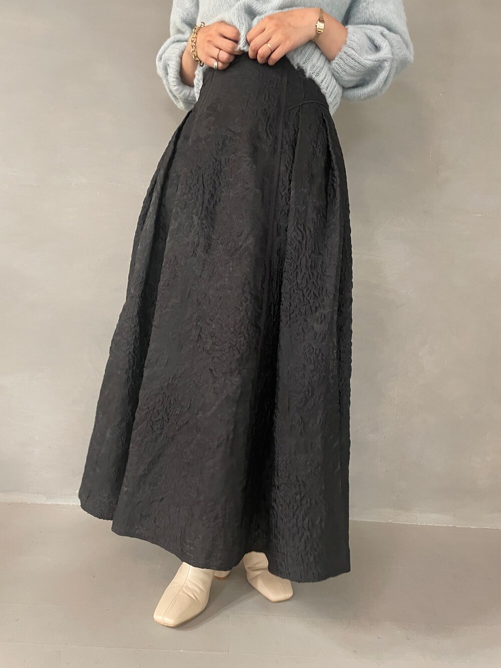 ホワイト系のブーツ、ブラック系のスカート、グリーン系のニット/セーターを着用したレディースの夏コーディネートの8枚目の写真