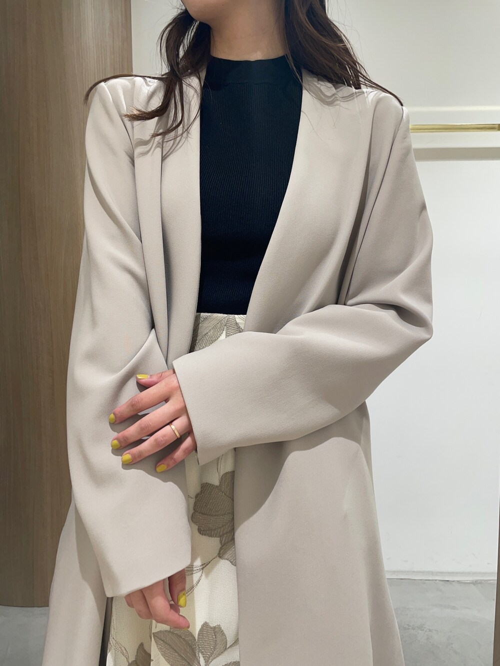 ブラック系のニット/セーター、ブラック系のサンダル、ベージュ系のスカートを着用したレディースの春コーディネートの3枚目の写真