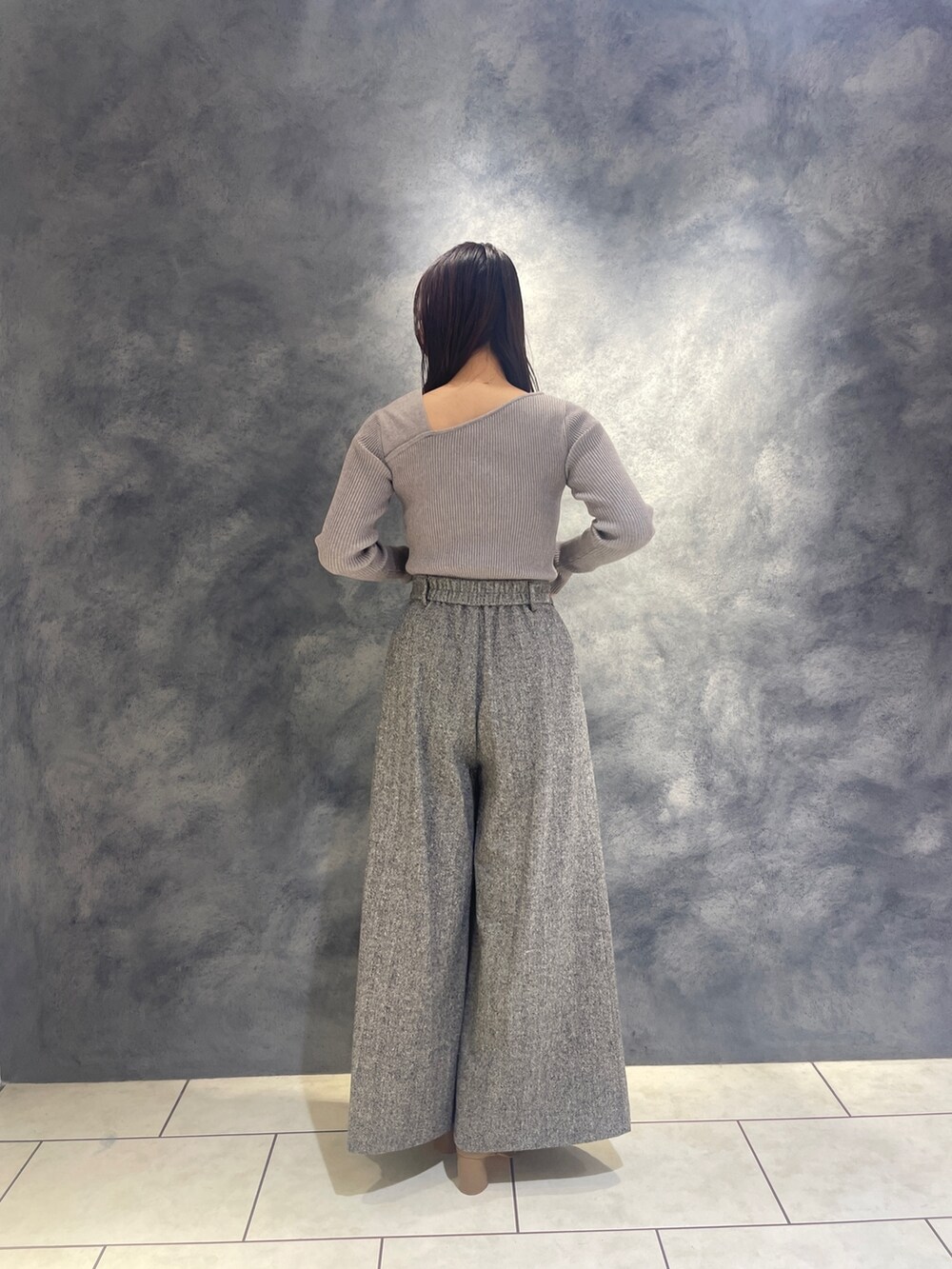 ホワイト系のノーカラーコート、グレー系のニット/セーター、ブラック系のその他パンツを着用したレディースの秋コーディネートの8枚目の写真