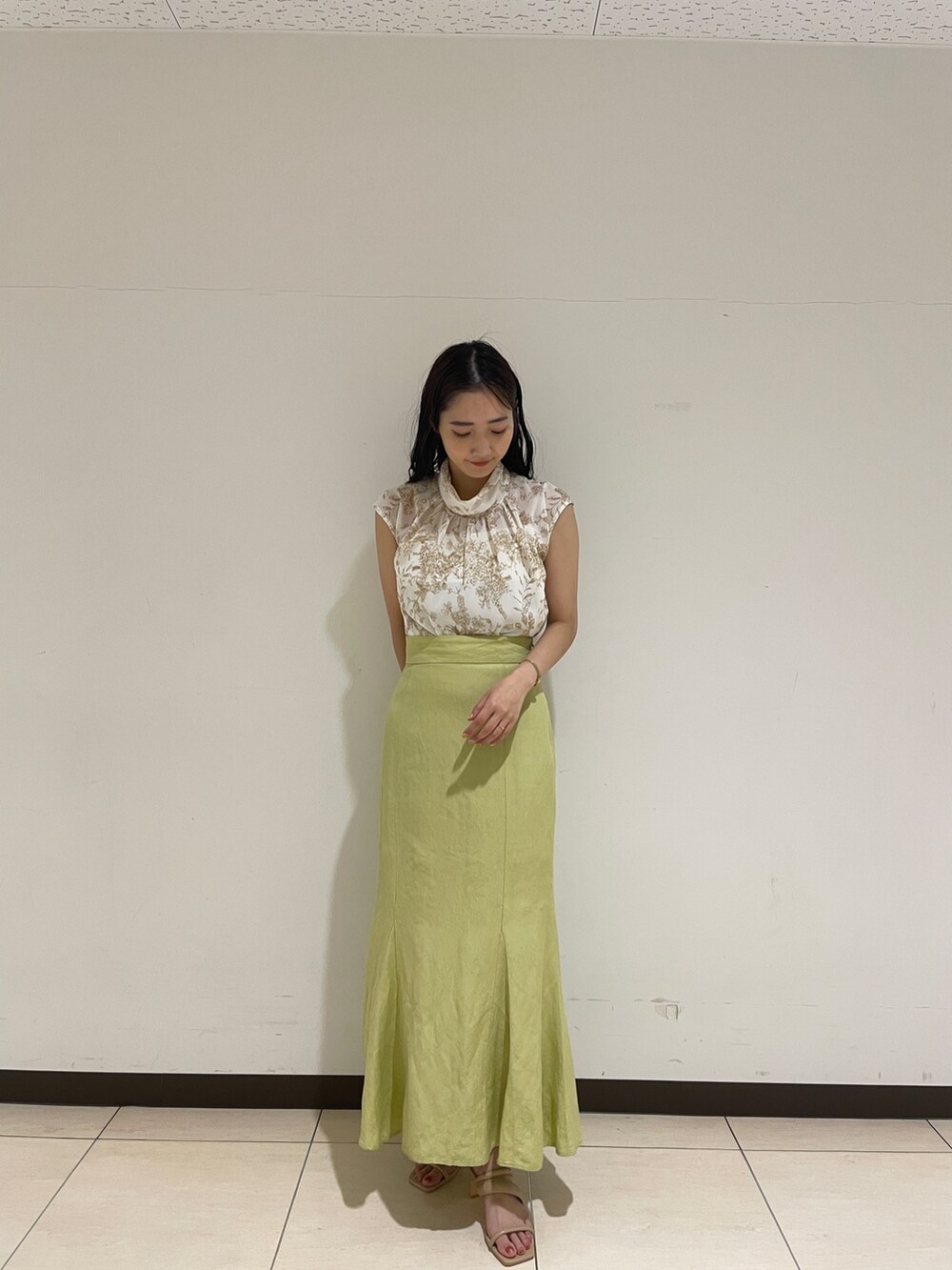 ベージュ系のシャツ/ブラウス、グリーン系のスカート、ベージュ系のサンダルを着用したレディースの春コーディネートの3枚目の写真