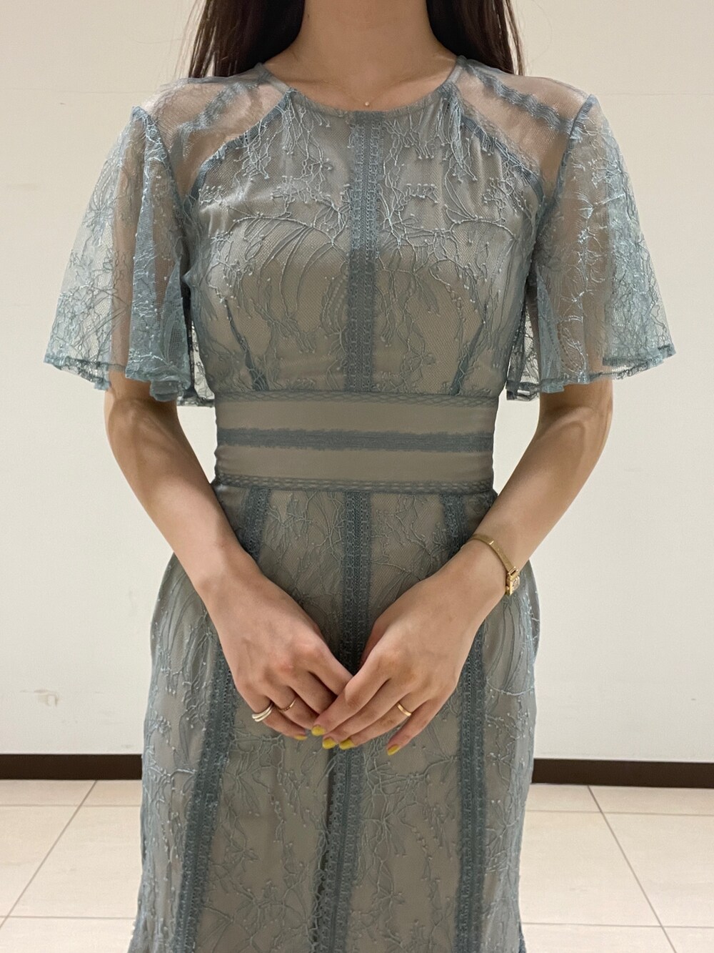 グリーン系のドレス、ベージュ系のパンプスを着用したレディースの春コーディネートの7枚目の写真