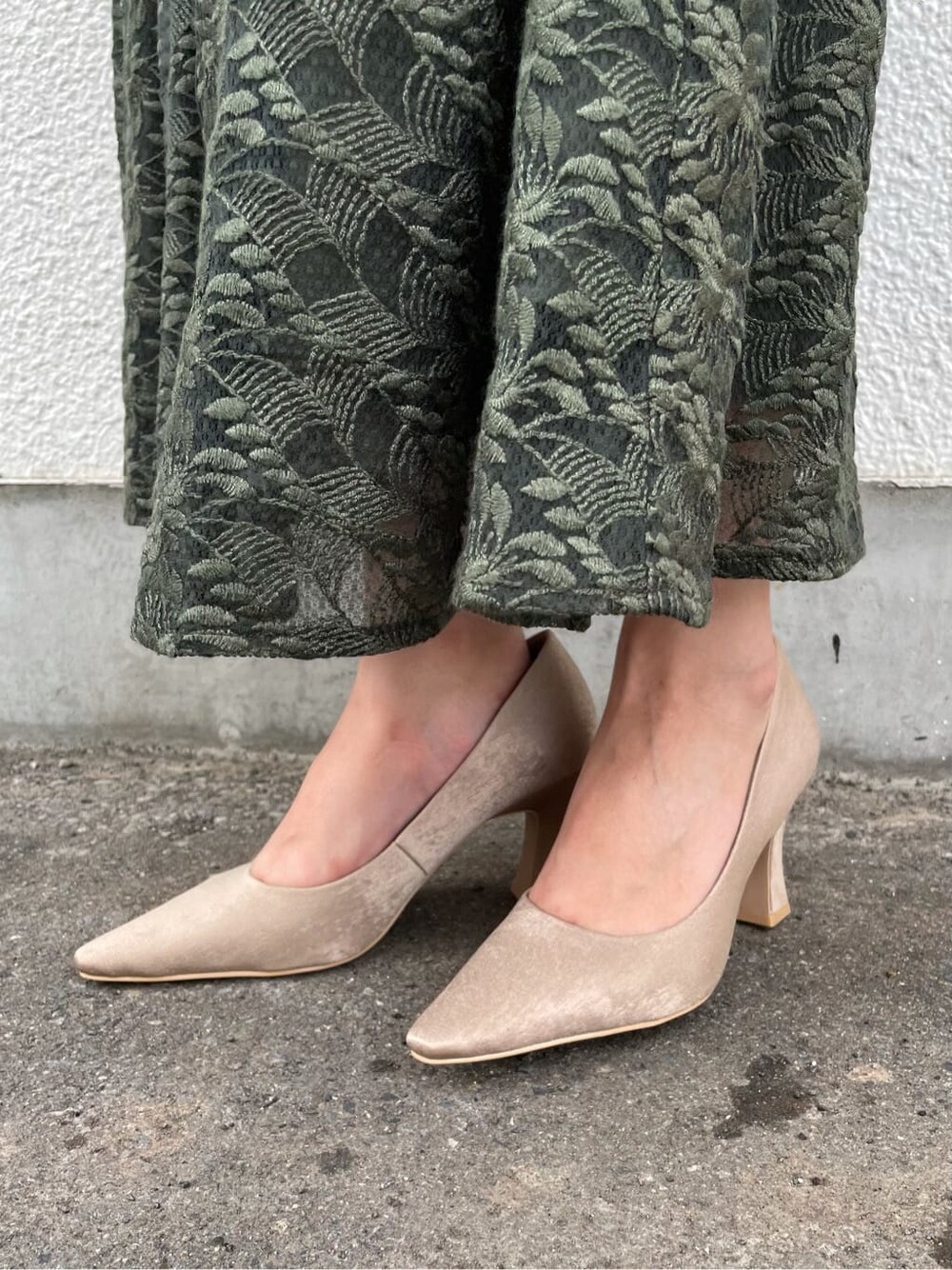 グリーン系のドレス、ベージュ系のパンプス、ブラウン系のクラッチバッグを着用したレディースの夏コーディネートの6枚目の写真