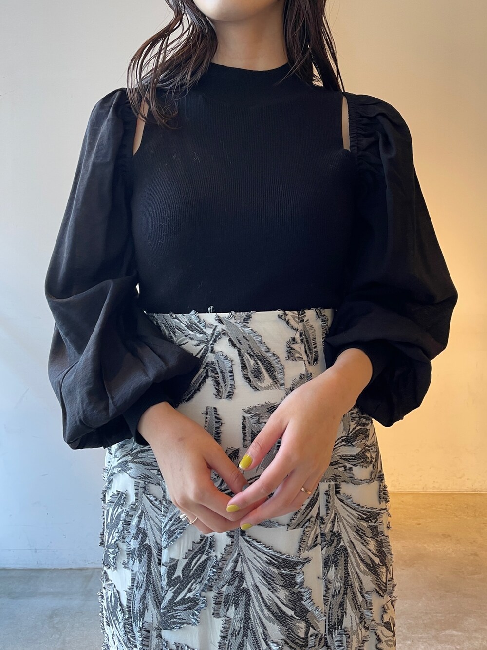 ブラック系のスカート、ブラック系のニット/セーター、ブラック系のブーツを着用したレディースの冬コーディネートの7枚目の写真