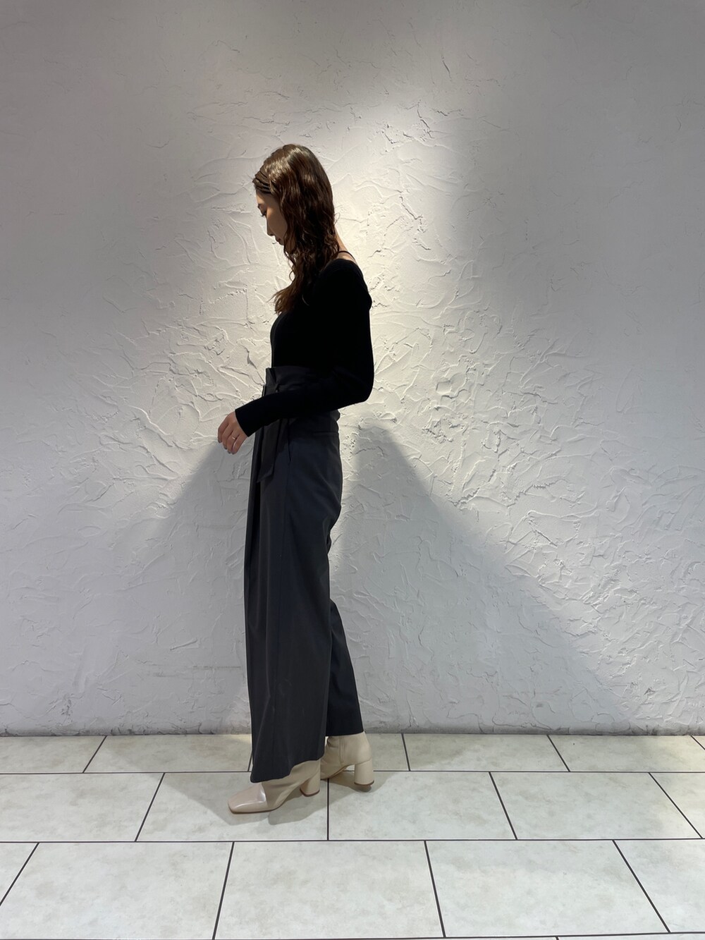 グレー系のその他パンツ、ブラック系のニット/セーター、ホワイト系のブーツを着用したレディースの冬コーディネートの5枚目の写真