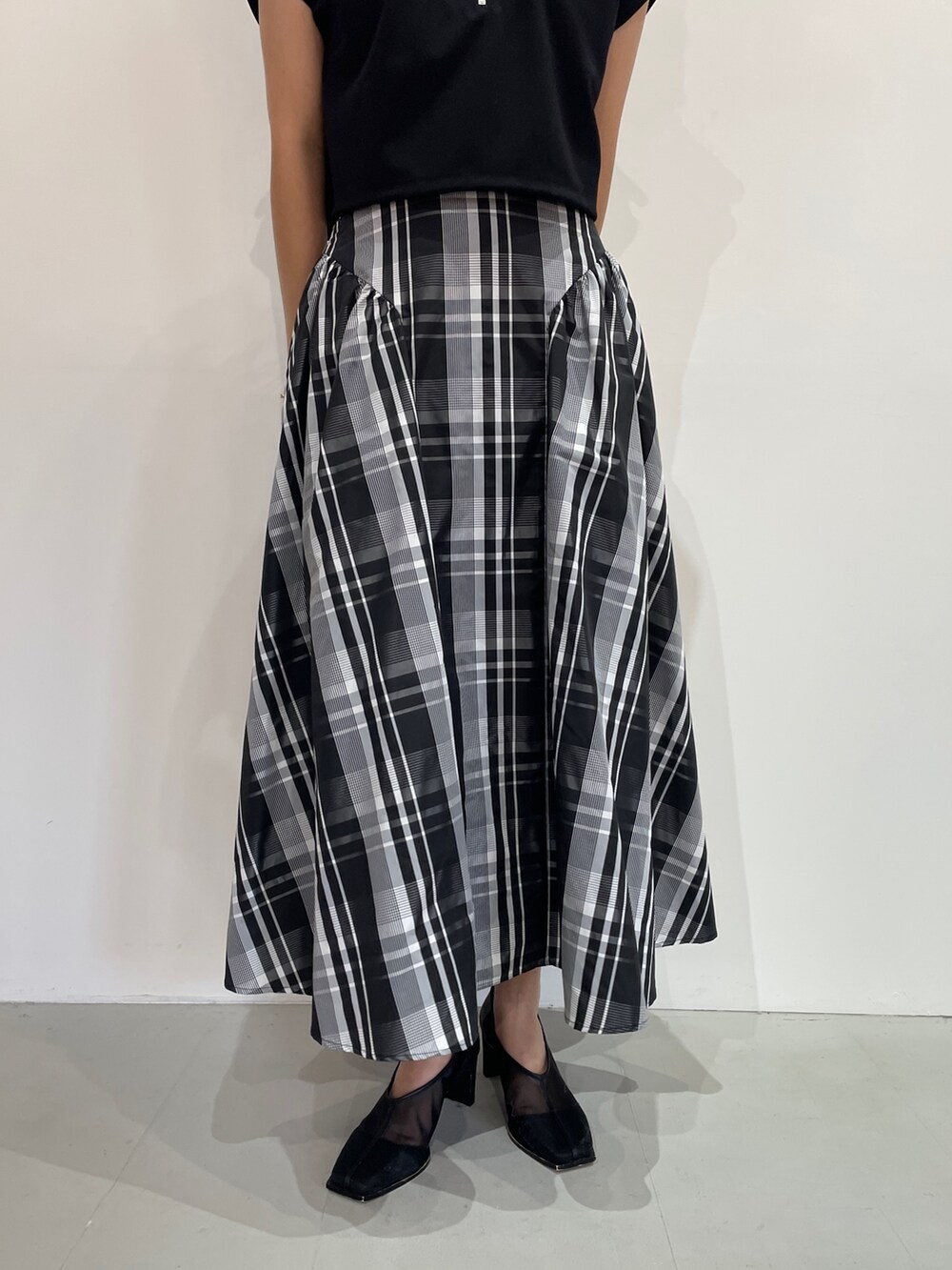 ブラック系のTシャツ/カットソー、ブラック系のパンプス、ホワイト系のスカートを着用したレディースの夏コーディネートの8枚目の写真