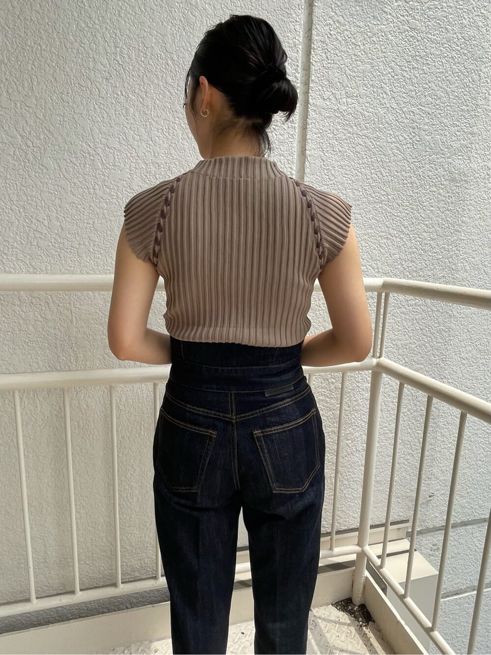 ブルー系のデニムパンツ、ホワイト系のサンダル、ベージュ系のニット/セーターを着用したレディースの夏コーディネートの4枚目の写真