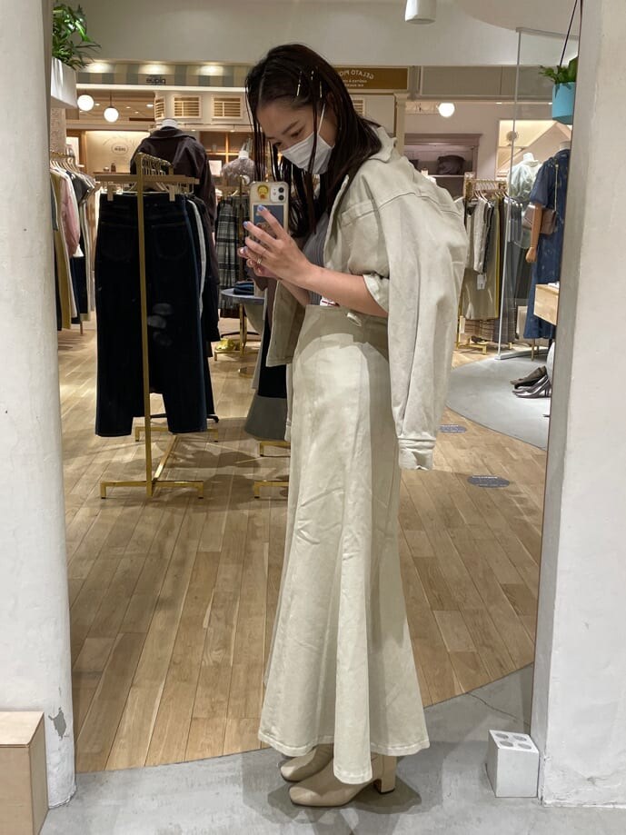 ベージュ系のデニムジャケット、ベージュ系のスカート、ベージュ系のニット/セーターを着用したレディースの夏コーディネートの2枚目の写真