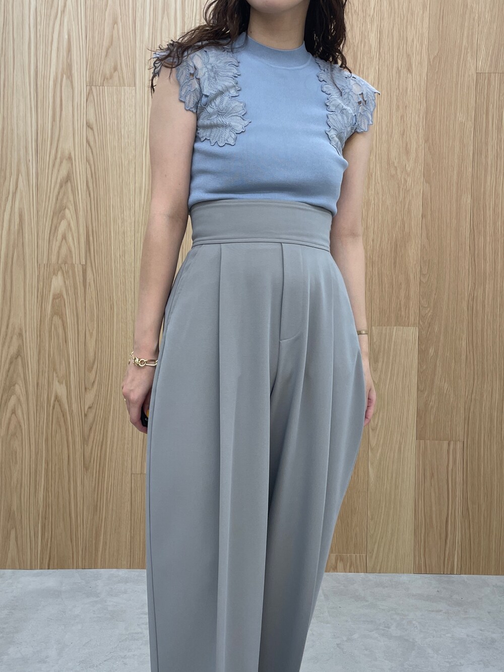 ブルー系のニット/セーター、ブラック系のサンダル、グレー系のその他パンツを着用したレディースの夏コーディネートの5枚目の写真