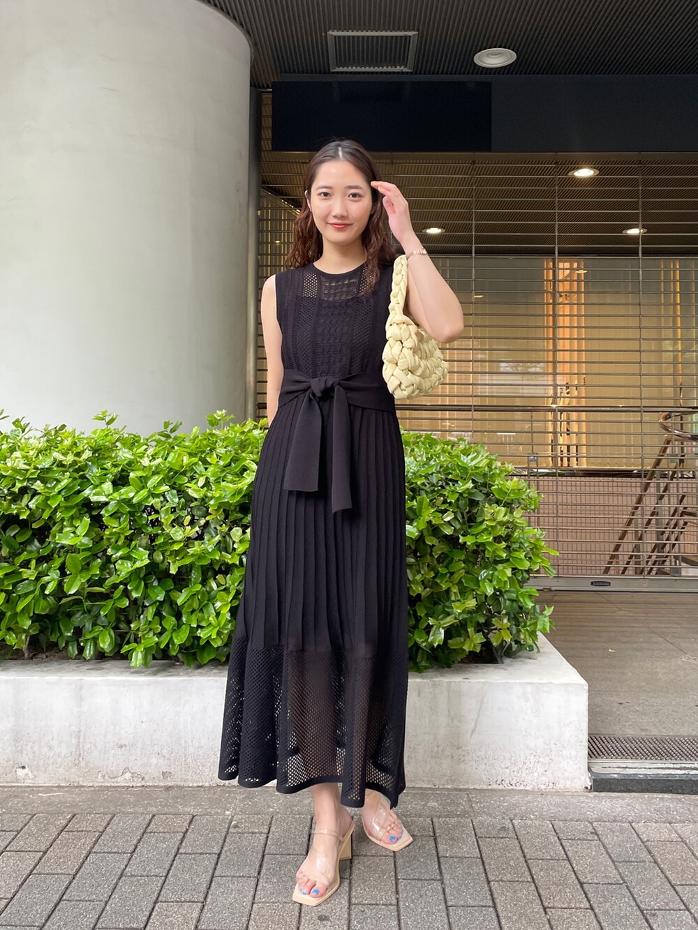 ブラック系のシャツ/ブラウス、ベージュ系のハンドバッグ、ブラック系のワンピースを着用したレディースの春コーディネートの6枚目の写真