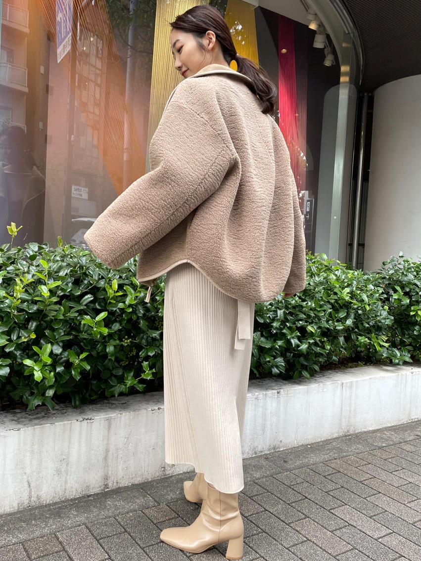 ベージュ系のブーツ、ブラウン系のブルゾン、ホワイト系のワンピースを着用したレディースの秋コーディネートの3枚目の写真