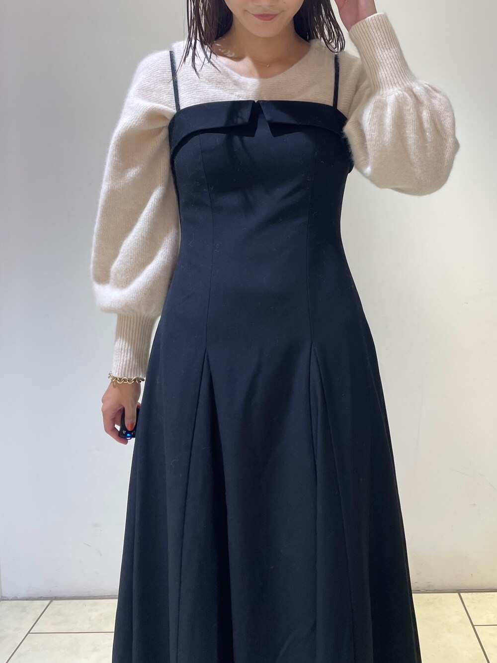 ホワイト系のニット/セーター、ブラック系のワンピース、ブラック系のブーツを着用したレディースの秋コーディネートの8枚目の写真