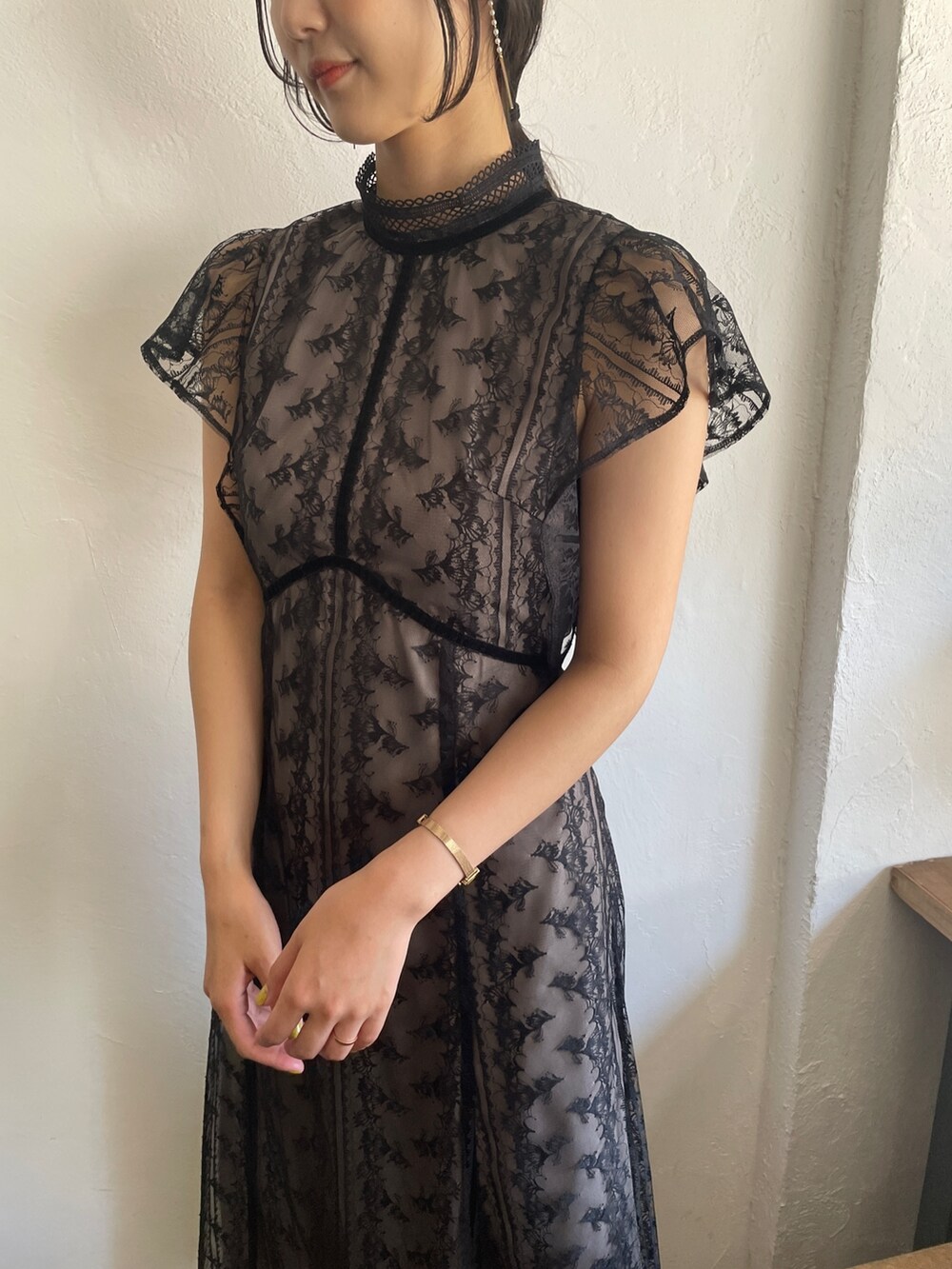 ゴールド系のパンプス、ブラック系のドレスを着用したレディースの夏コーディネートの7枚目の写真