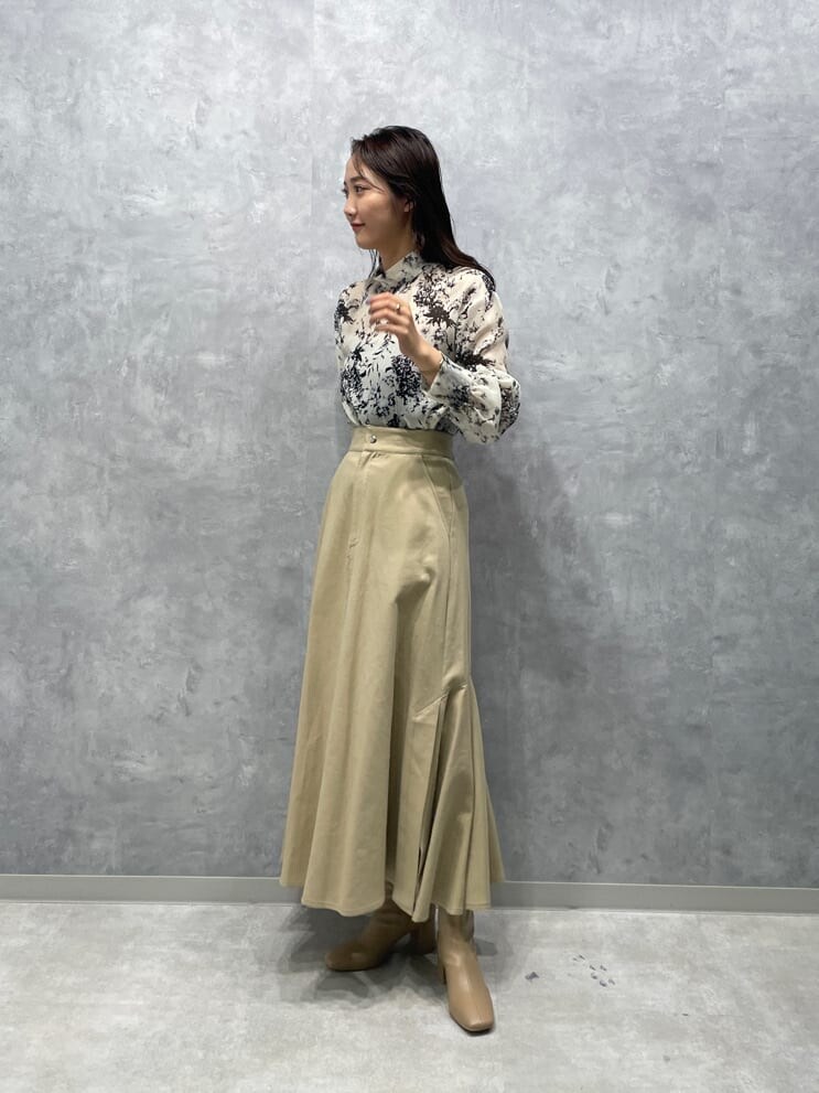 ベージュ系のスカート、グレー系のシャツ/ブラウス、ベージュ系のブーツを着用したレディースの夏コーディネートの2枚目の写真