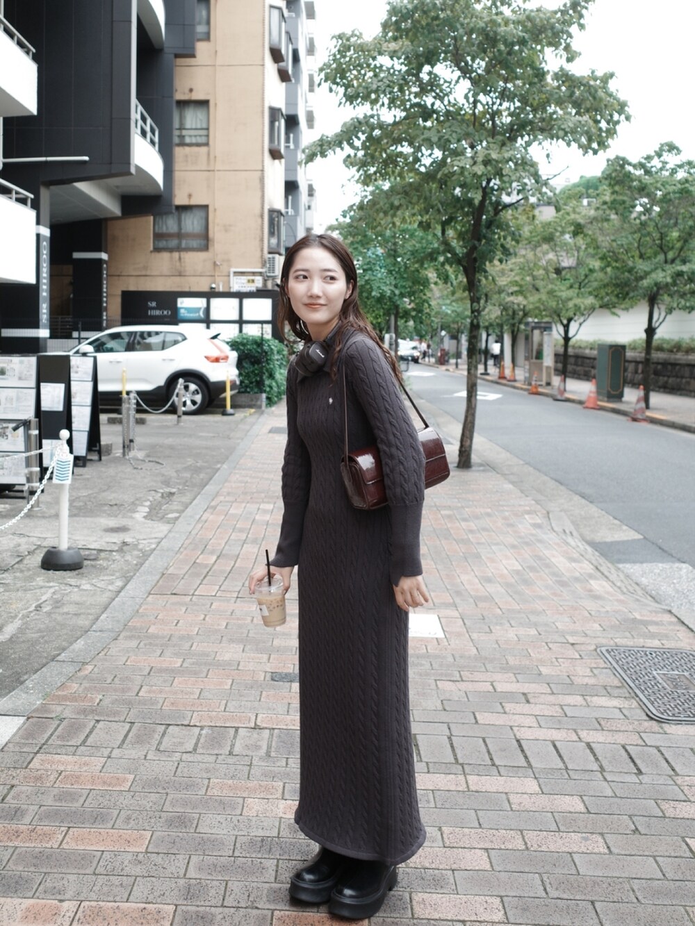 グレー系のワンピース、ホワイト系のブルゾン、ブラック系のブーツを着用したレディースの夏コーディネートの5枚目の写真