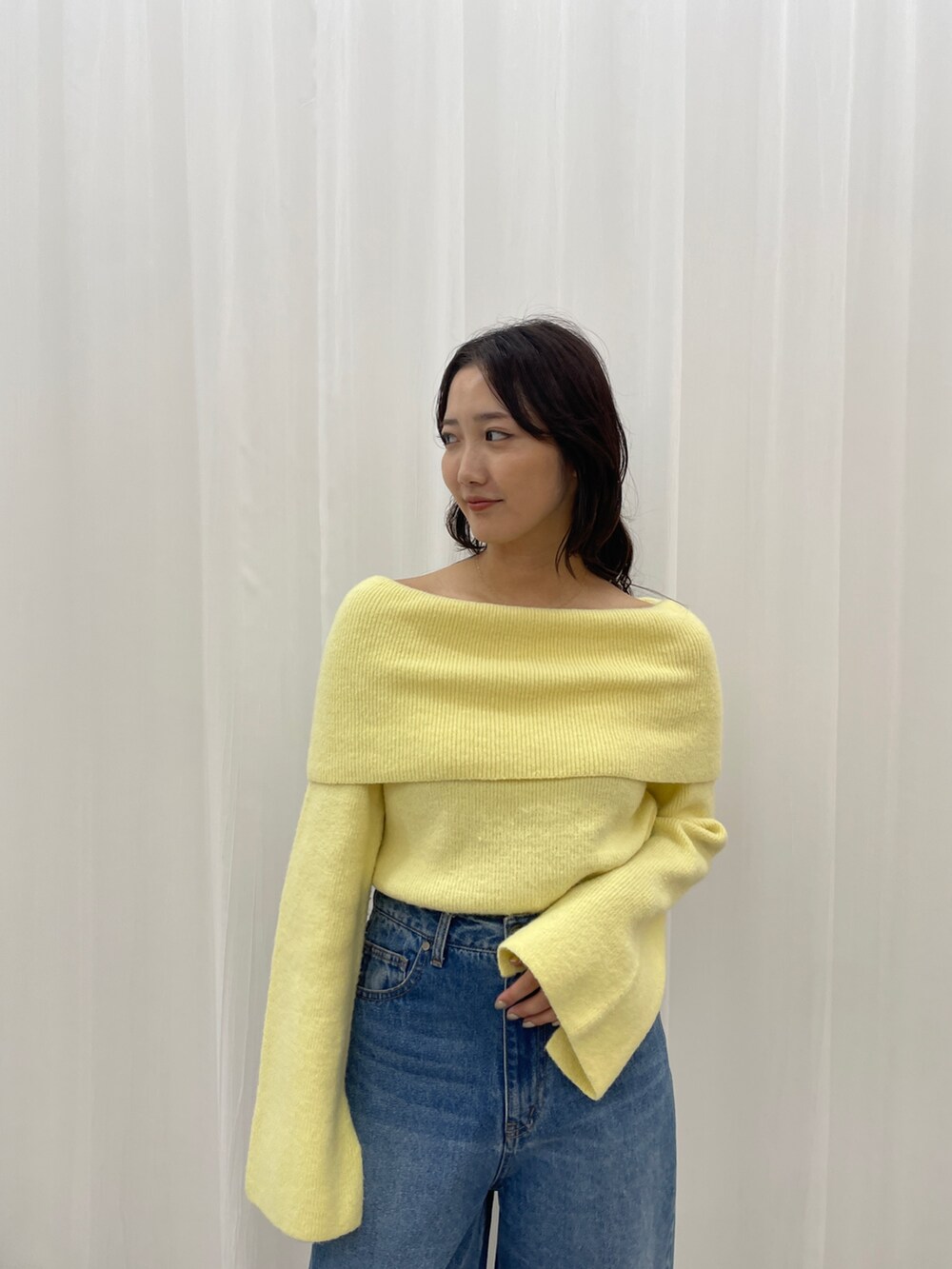 ブルー系のデニムパンツ、ホワイト系のブーツ、イエロー系のニット/セーターを着用したレディースの秋コーディネートの6枚目の写真