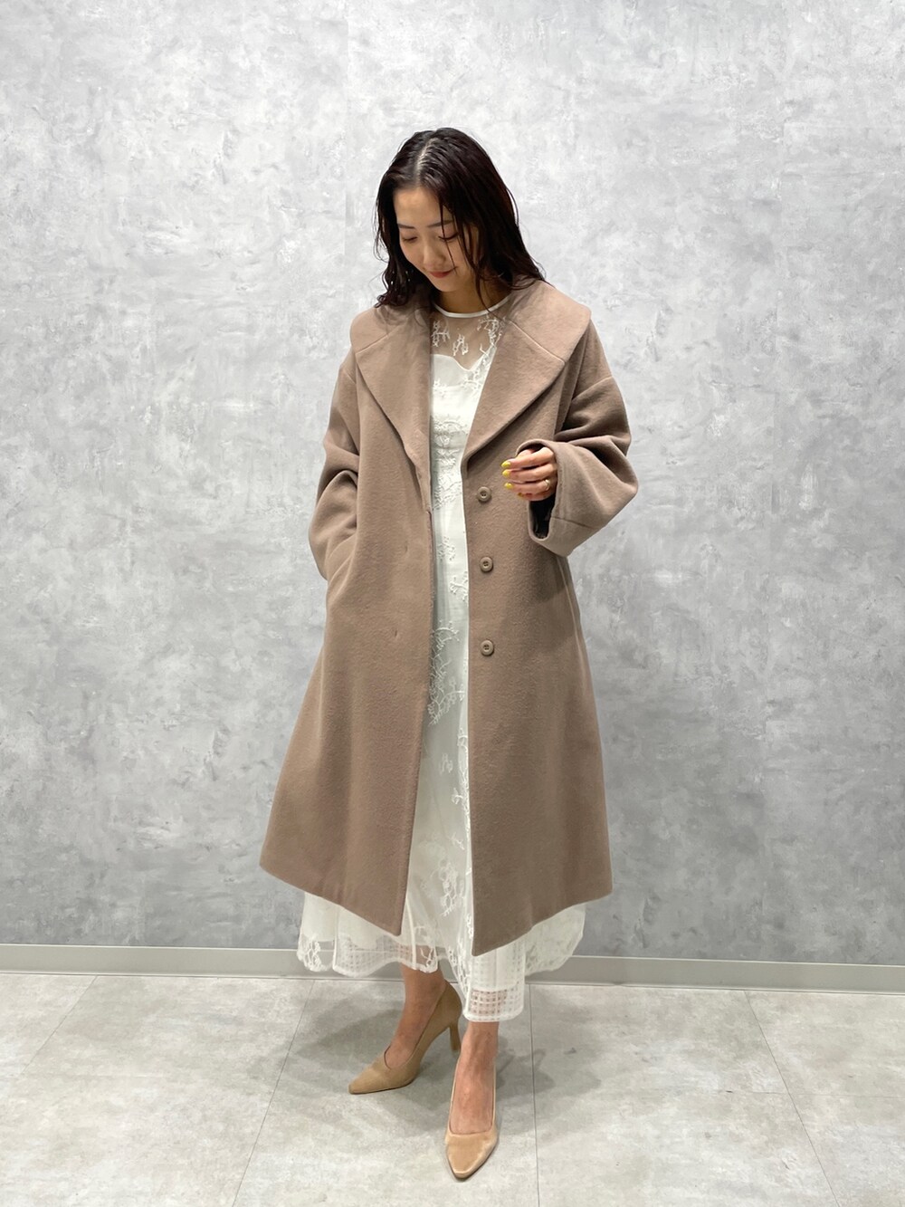 ベージュ系のその他アウター、ゴールド系のパンプス、ホワイト系のドレスを着用したレディースの冬コーディネートの2枚目の写真