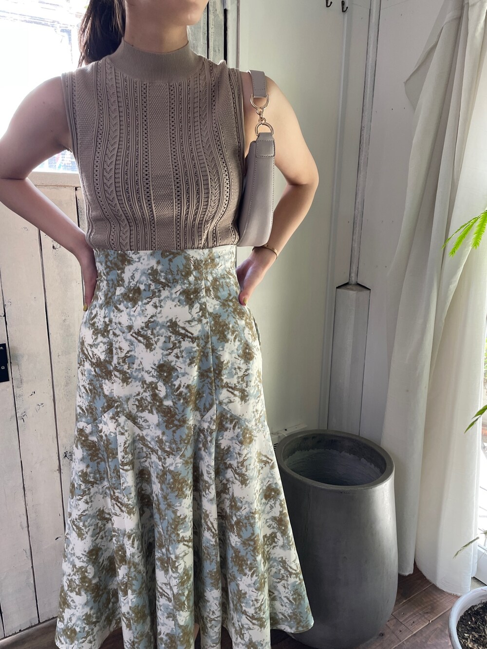 ベージュ系のサンダル、グリーン系のスカート、ベージュ系のニット/セーターを着用したレディースの春コーディネートの5枚目の写真