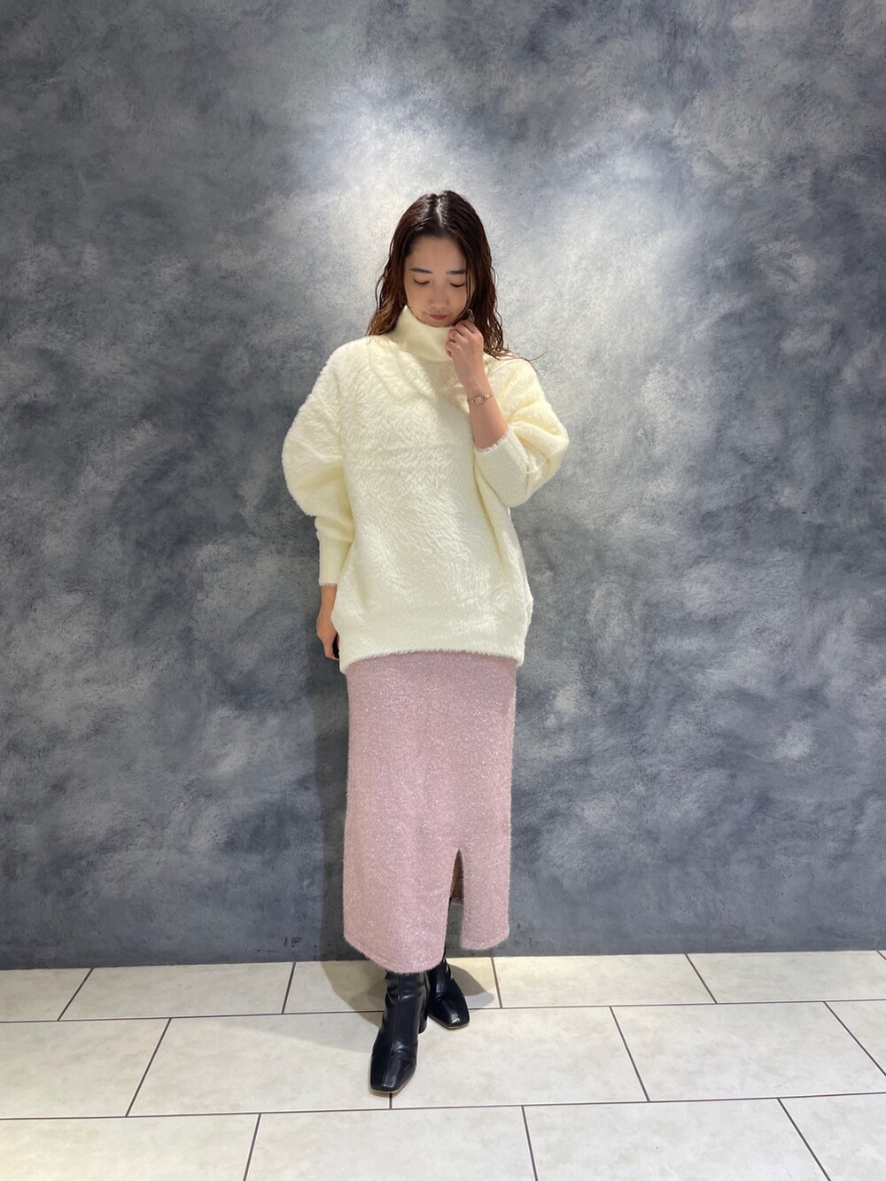 ホワイト系のニット/セーター、ピンク系のスカート、ブラック系のブーツを着用したレディースの秋コーディネートの2枚目の写真