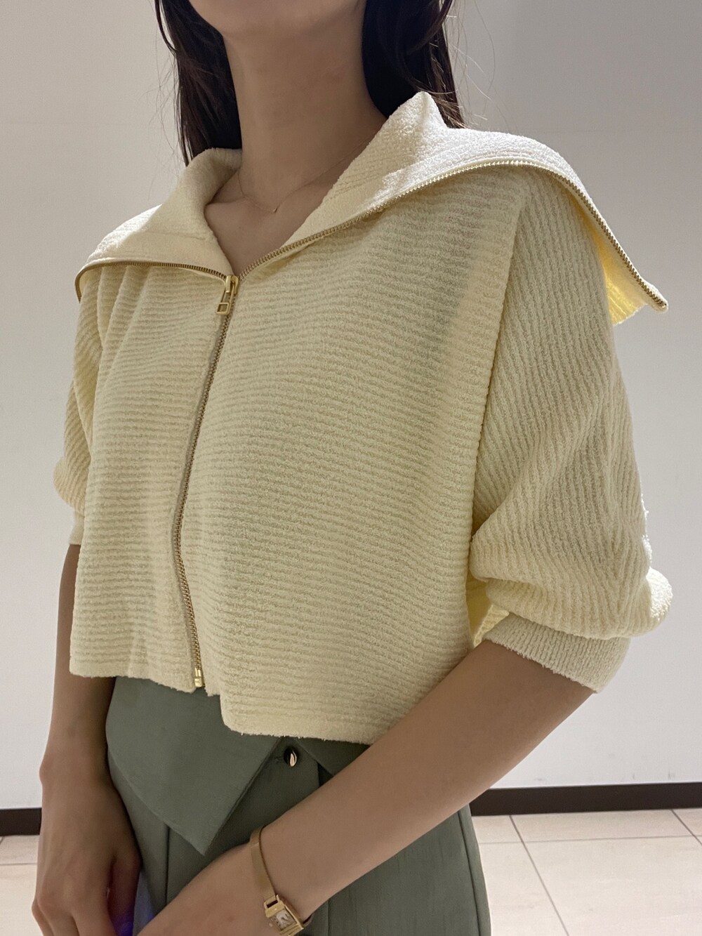 ホワイト系のカーディガン/ボレロ、グリーン系のスカートを着用したレディースの春コーディネートの6枚目の写真