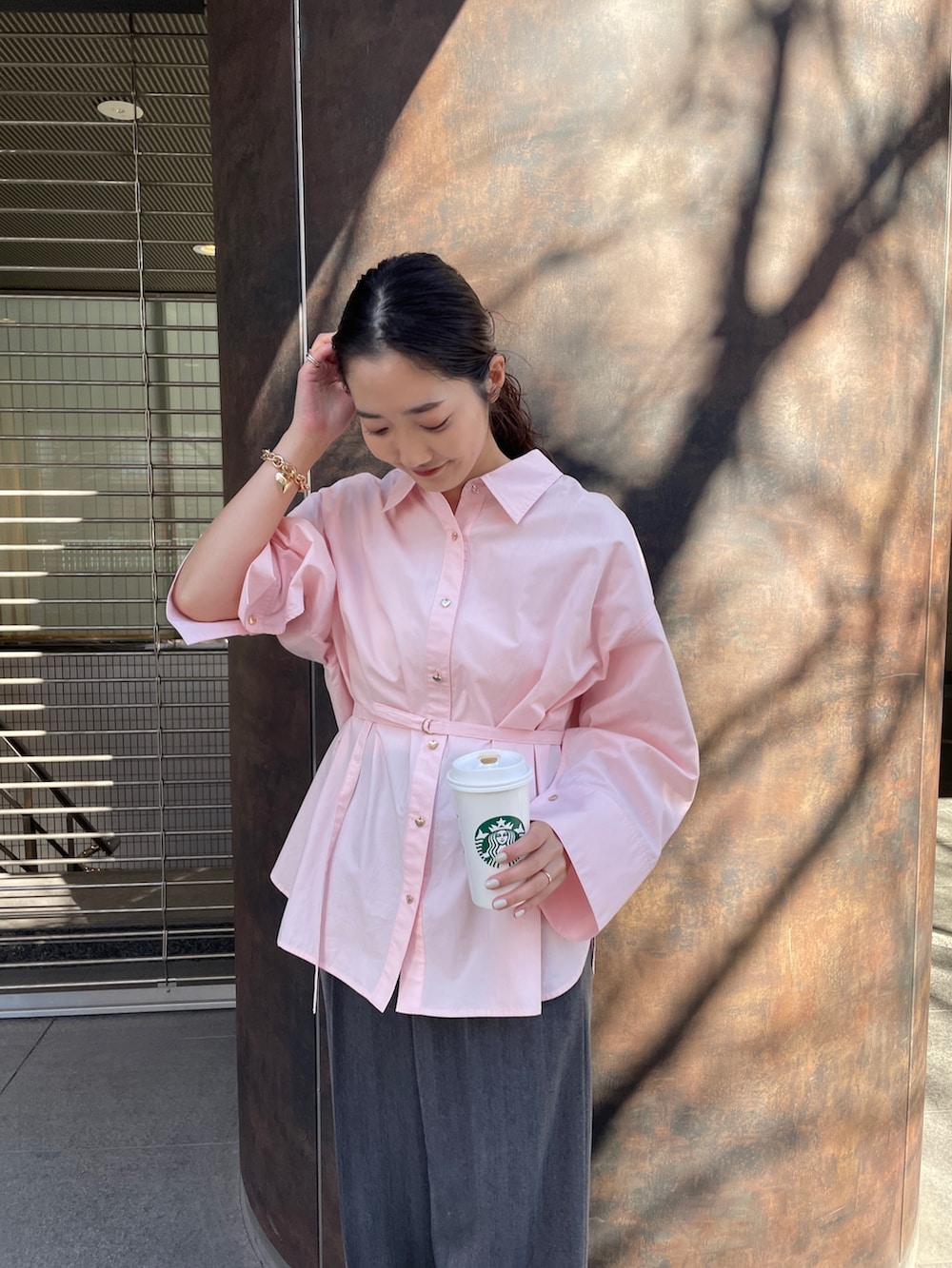 グレー系のその他パンツ、ピンク系のシャツ/ブラウス、ブラック系のパンプスを着用したレディースの冬コーディネートの5枚目の写真