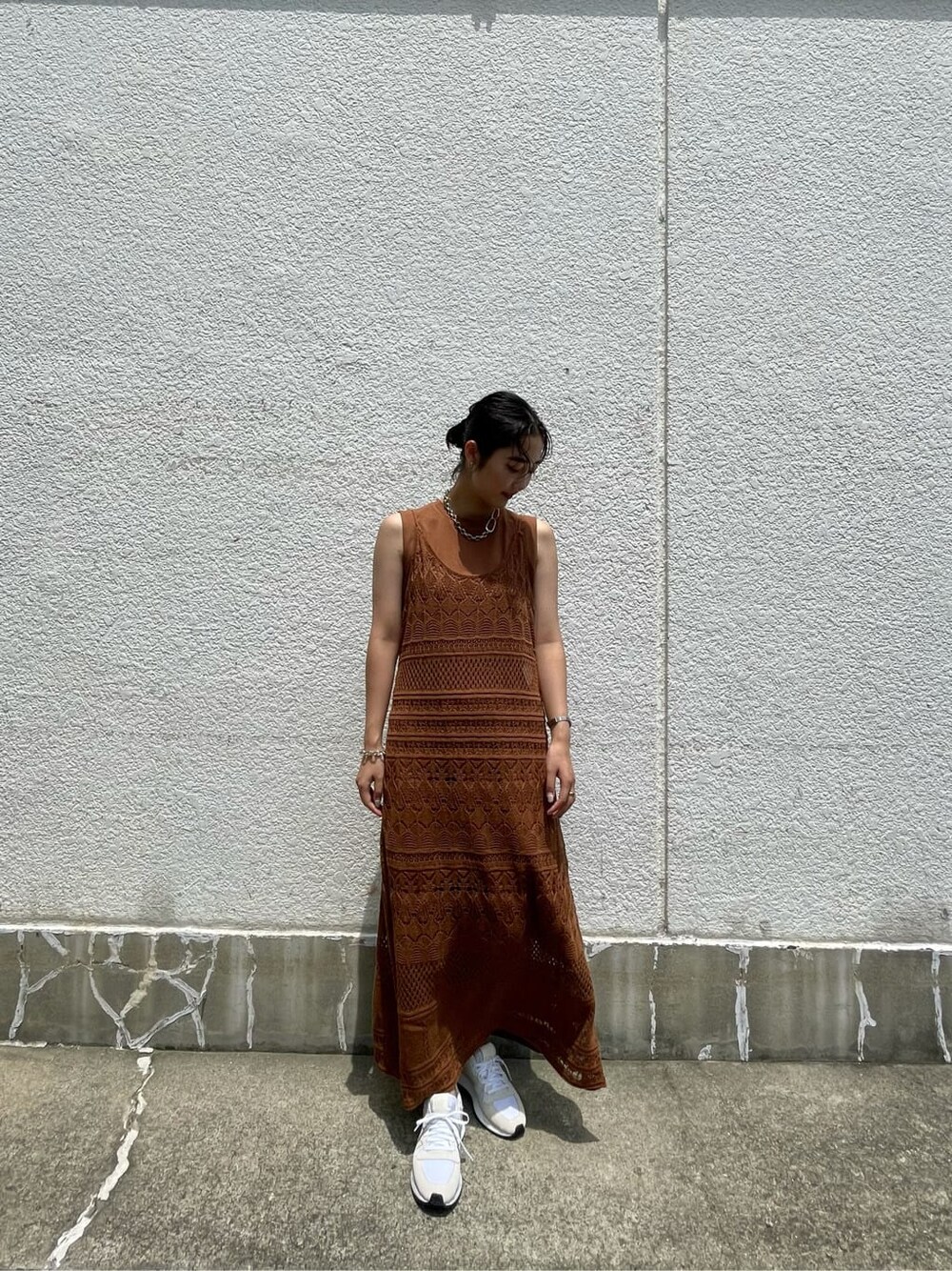 ブラウン系のワンピース、ホワイト系のスニーカー、シルバー系のブレスレットを着用したレディースの夏コーディネートの2枚目の写真