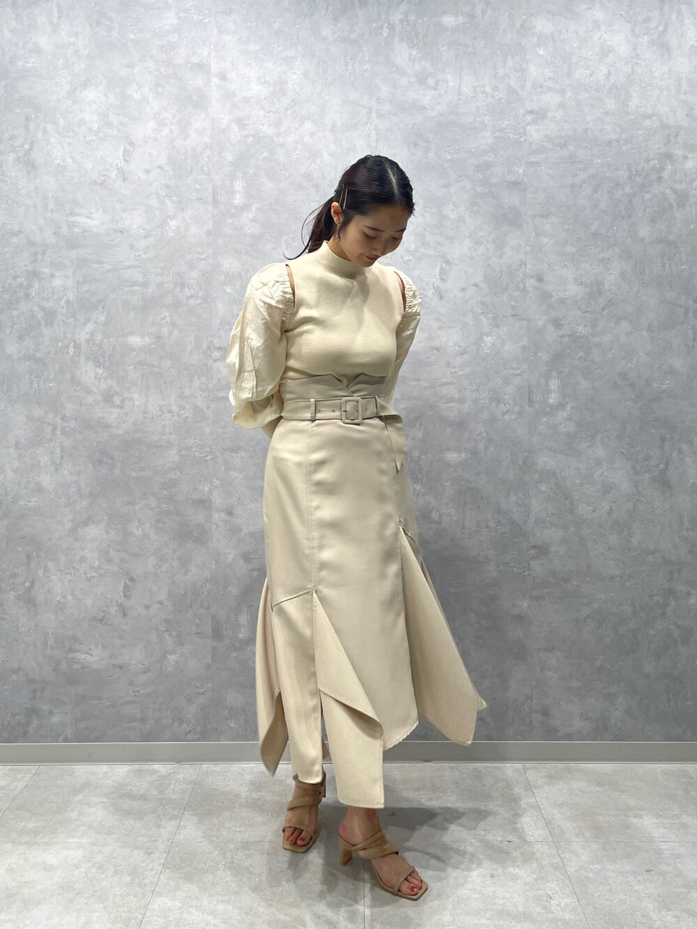 ベージュ系のサンダル、ホワイト系のニット/セーター、ホワイト系のスカートを着用したレディースの冬コーディネートの4枚目の写真