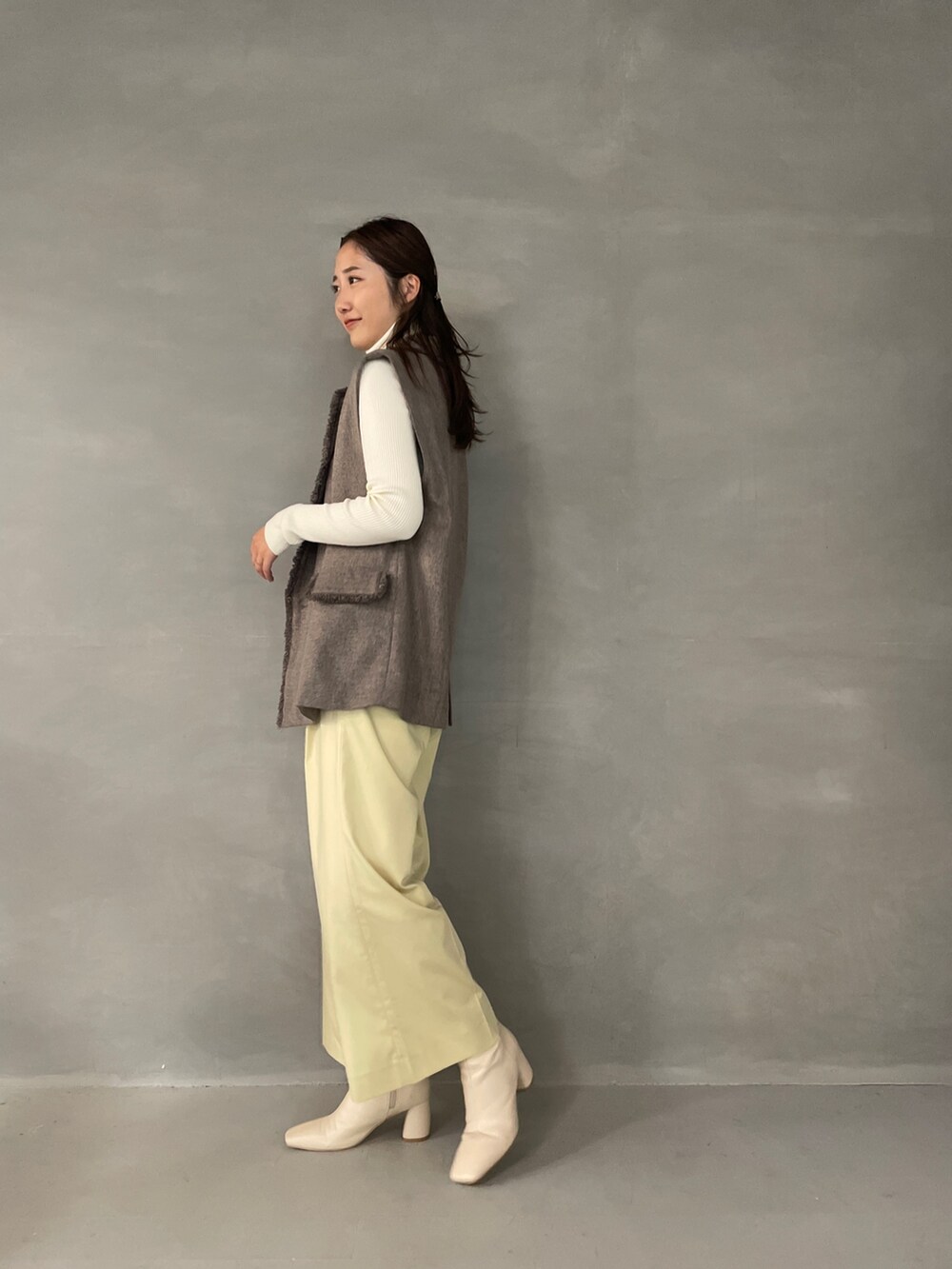 イエロー系のその他パンツ、ホワイト系のブーツ、グレー系のベストを着用したレディースの夏コーディネートの4枚目の写真