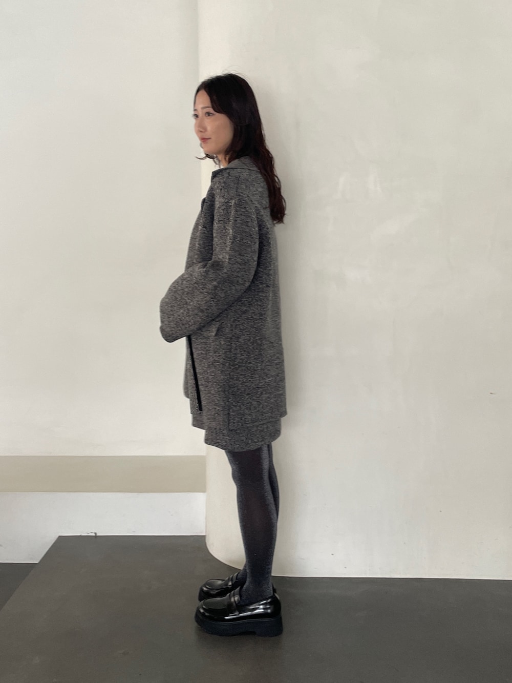 グレー系のワンピース、ブラック系のローファー、グレー系のテーラードジャケットを着用したレディースの冬コーディネートの4枚目の写真