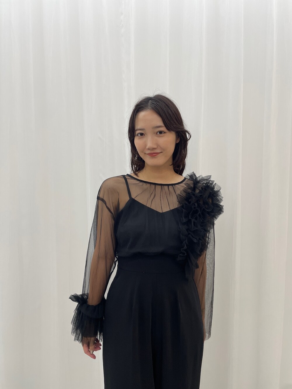 ブラック系のパンツドレス、その他のパンプスを着用したレディースの秋コーディネートの6枚目の写真