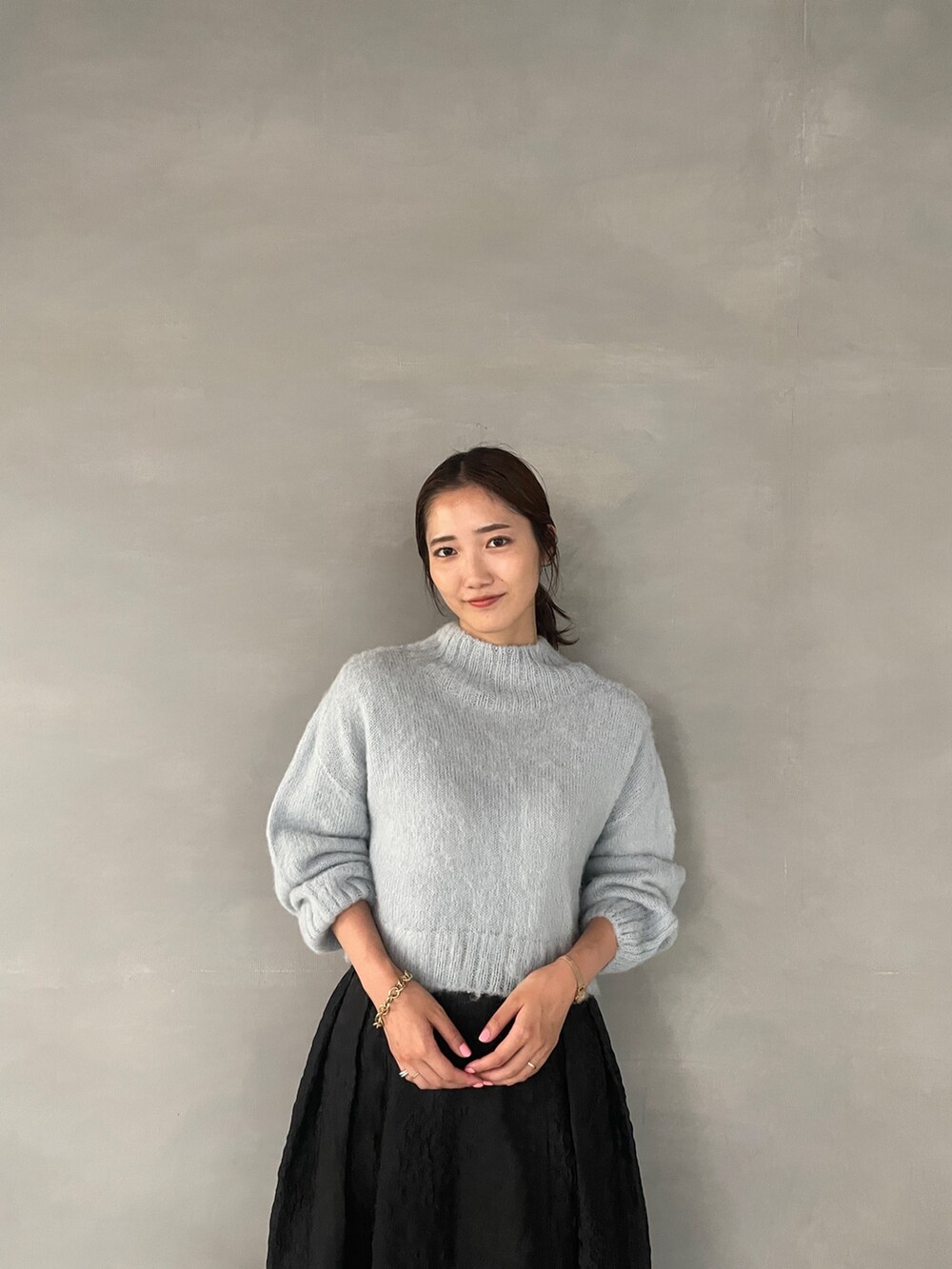 ホワイト系のブーツ、ブラック系のスカート、グリーン系のニット/セーターを着用したレディースの夏コーディネートの6枚目の写真