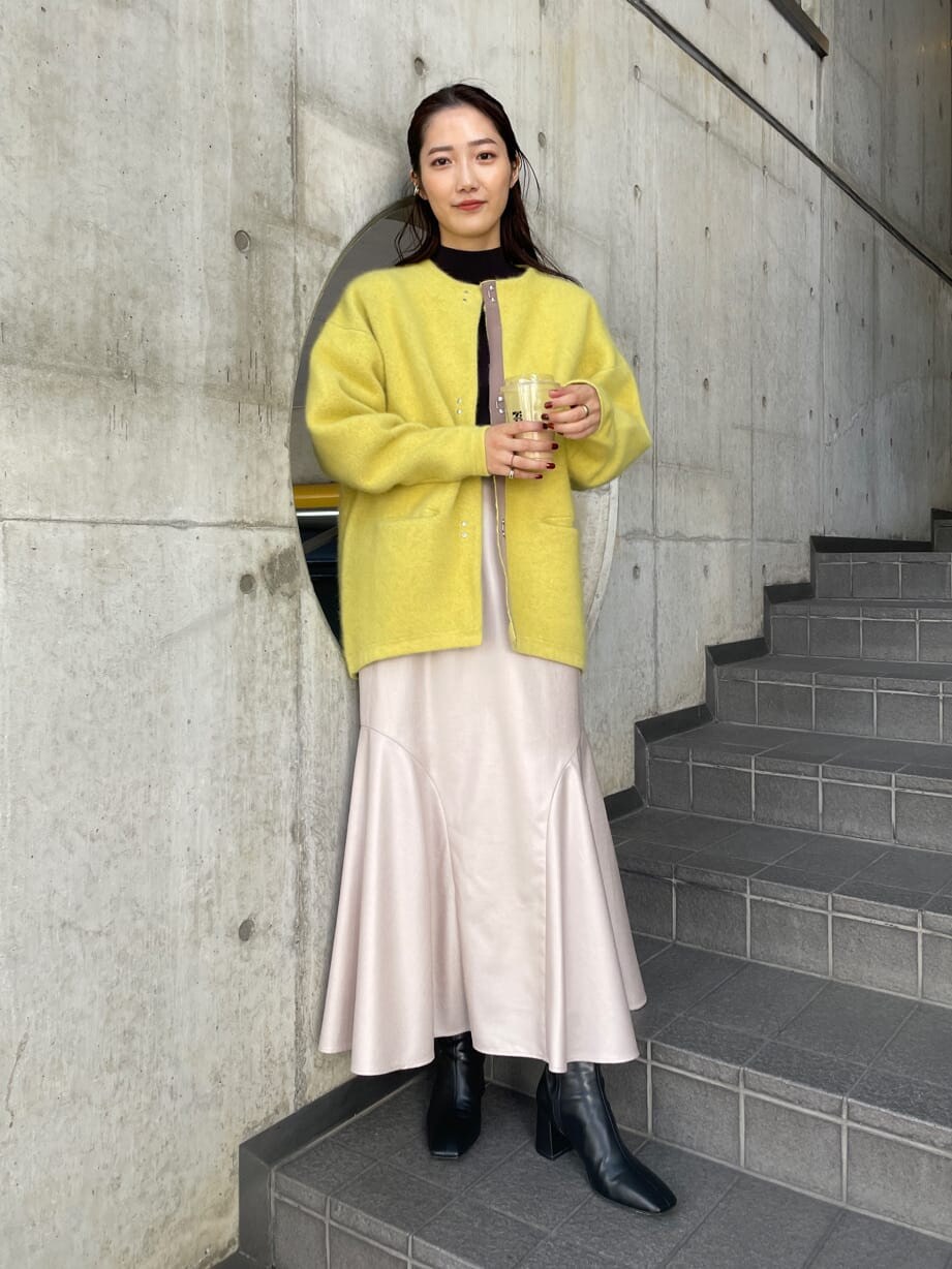 ブラック系のブーツ、イエロー系のカーディガン/ボレロ、グレー系のスカートを着用したレディースの秋コーディネートの2枚目の写真