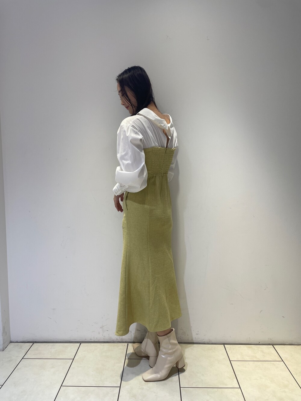 イエロー系のワンピース、ホワイト系のブーツを着用したレディースの秋コーディネートの5枚目の写真