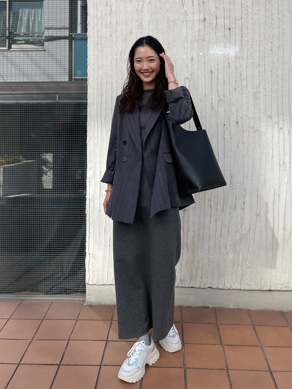 ホワイト系のスニーカー、グレー系のワンピース、グレー系のテーラードジャケットを着用したレディースの冬コーディネートの2枚目の写真