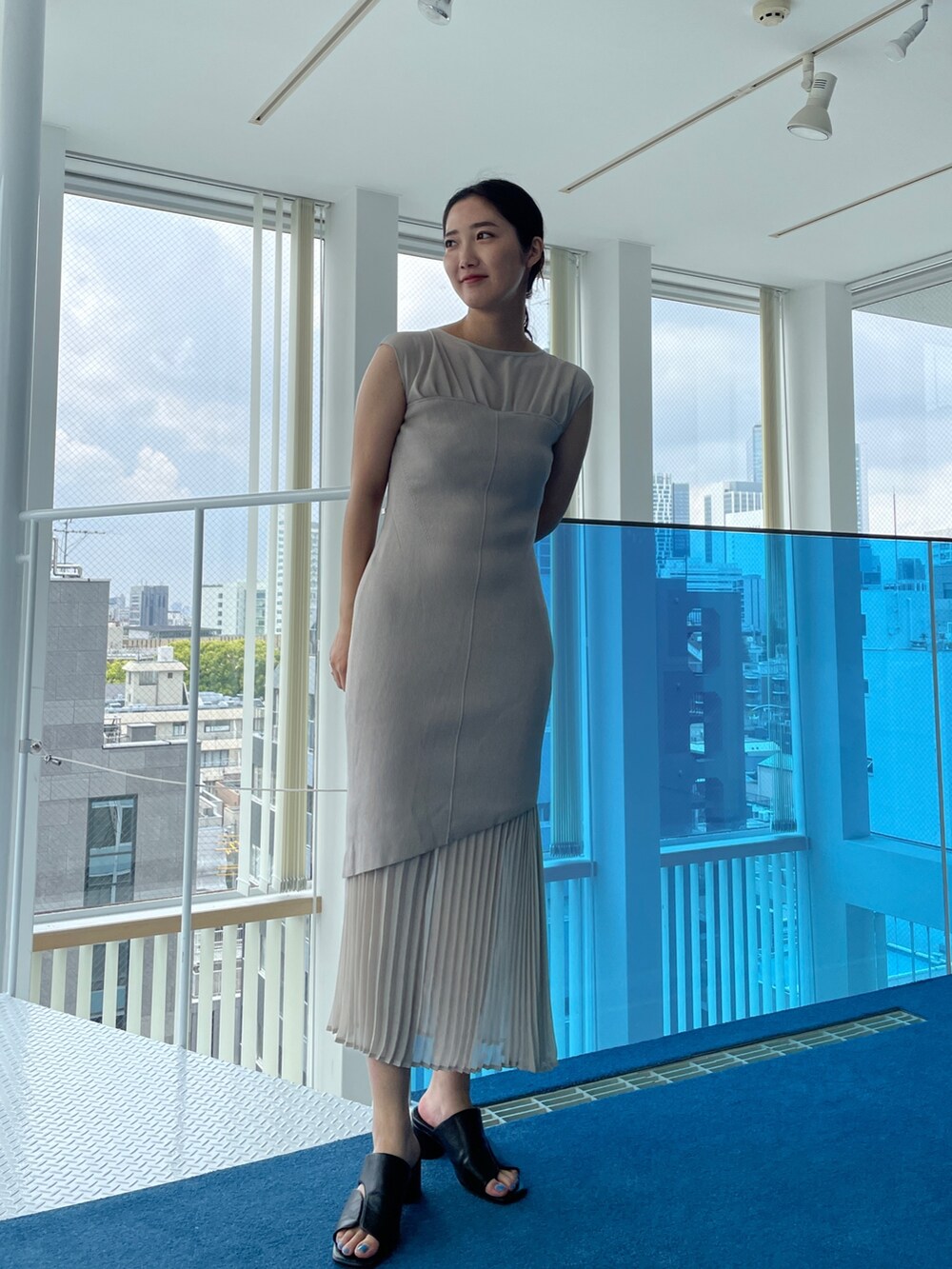 ブラック系のサンダル、ベージュ系のワンピースを着用したレディースの春コーディネートの3枚目の写真