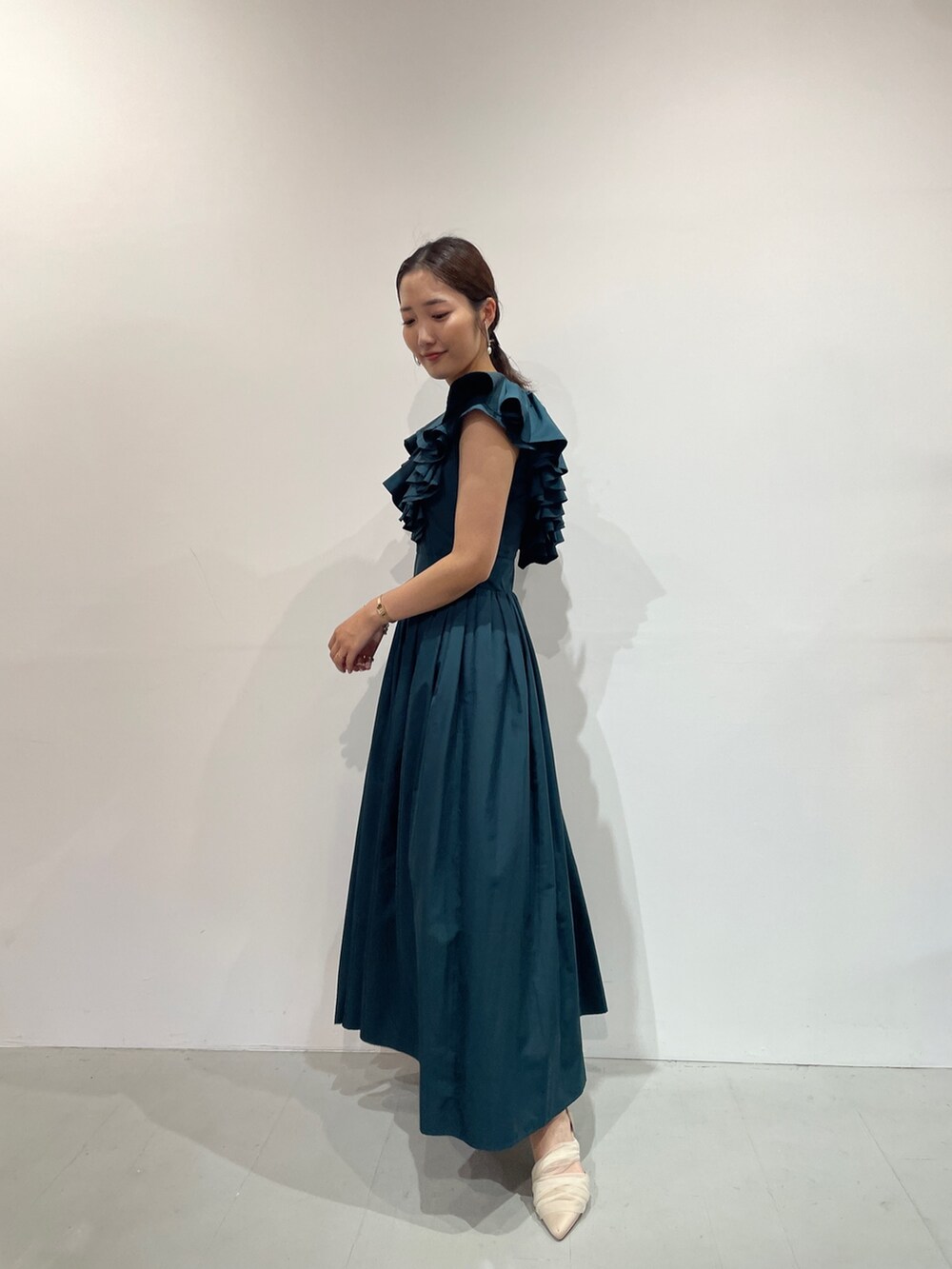 ベージュ系のパンプス、グリーン系のドレス、シルバー系のバレッタ/ヘアクリップを着用したレディースの夏コーディネートの2枚目の写真