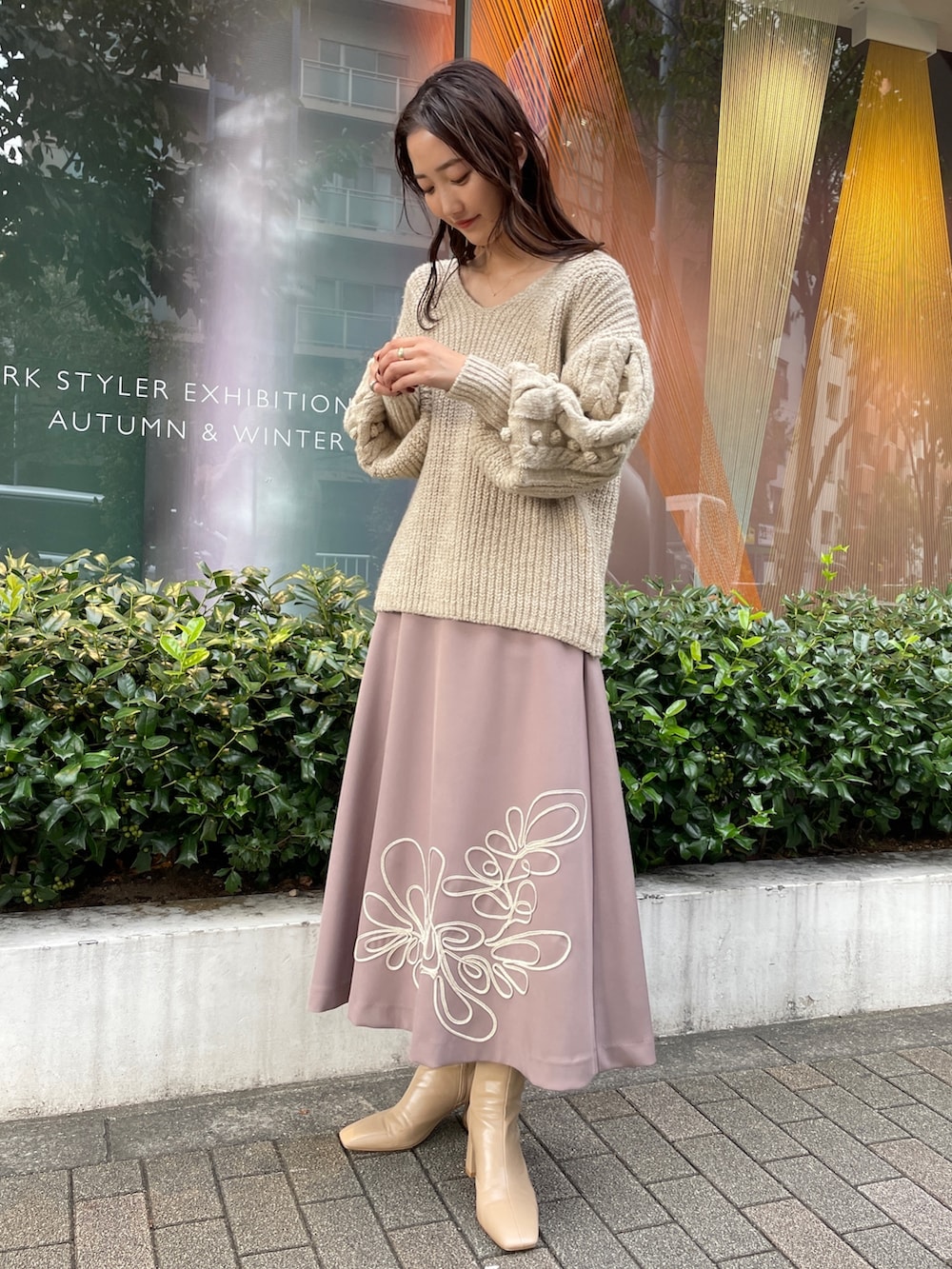 ホワイト系のニット/セーター、ホワイト系のその他アウター、ベージュ系のスカートを着用したレディースの秋コーディネートの3枚目の写真