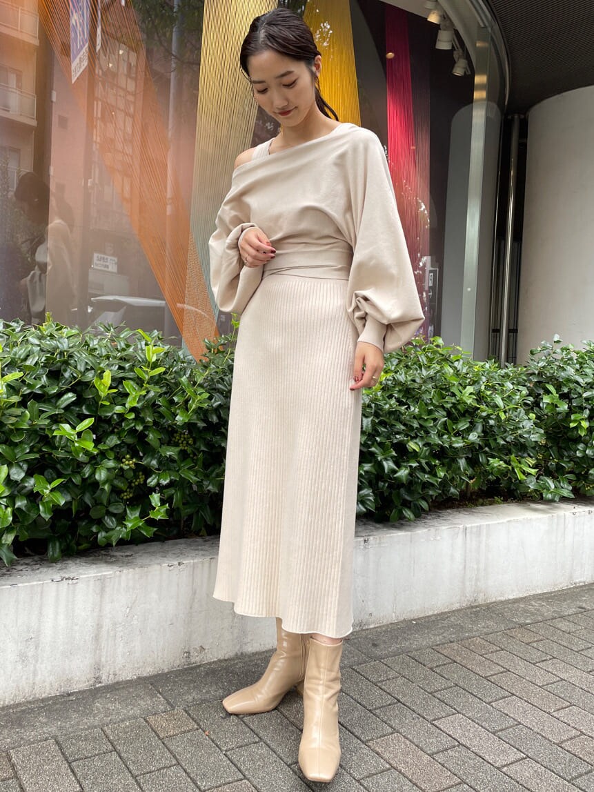 ベージュ系のブーツ、ブラウン系のブルゾン、ホワイト系のワンピースを着用したレディースの秋コーディネートの7枚目の写真