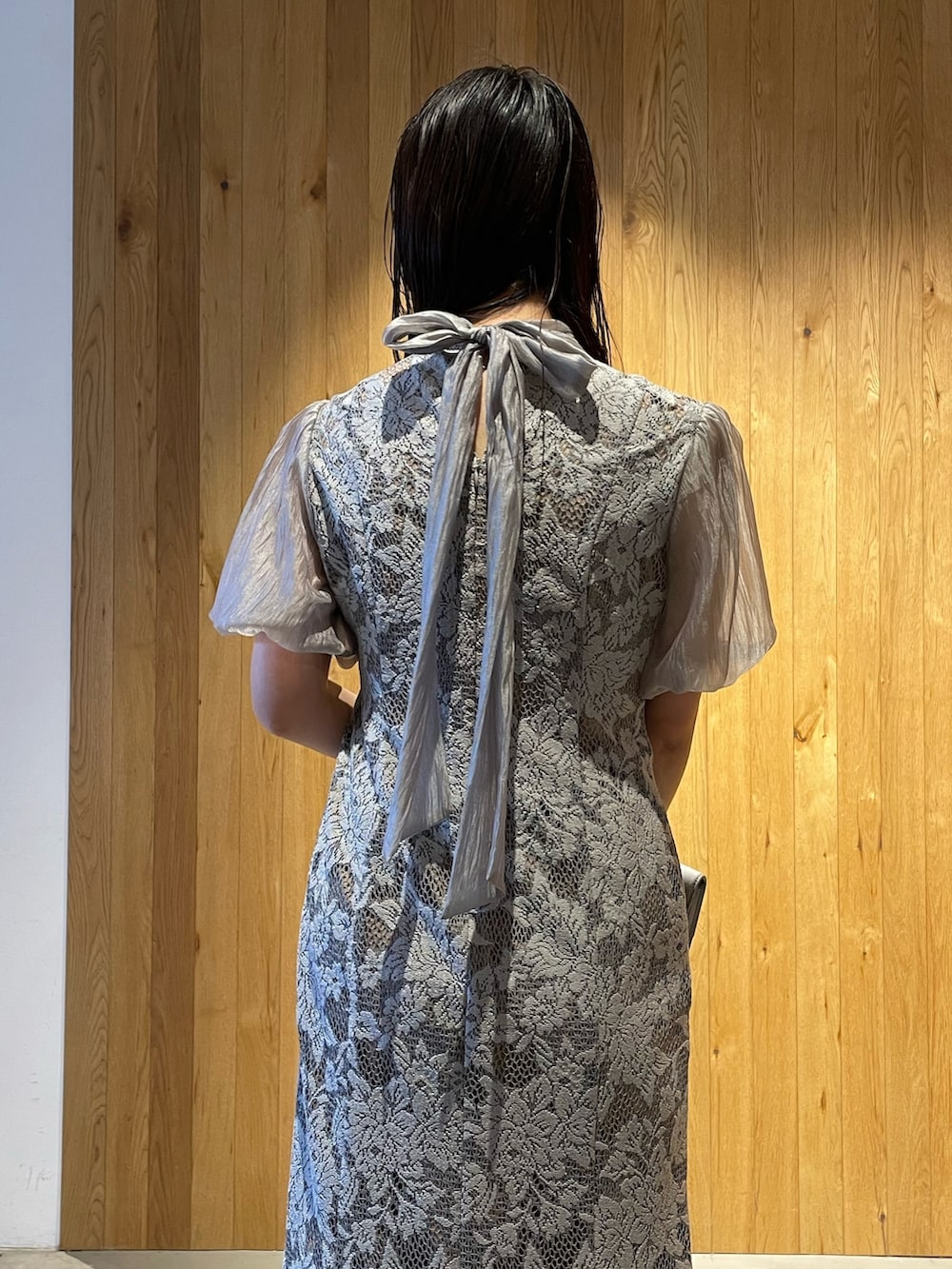 グレー系のパンプス、グレー系のクラッチバッグ、グレー系のドレスを着用したレディースの冬コーディネートの7枚目の写真