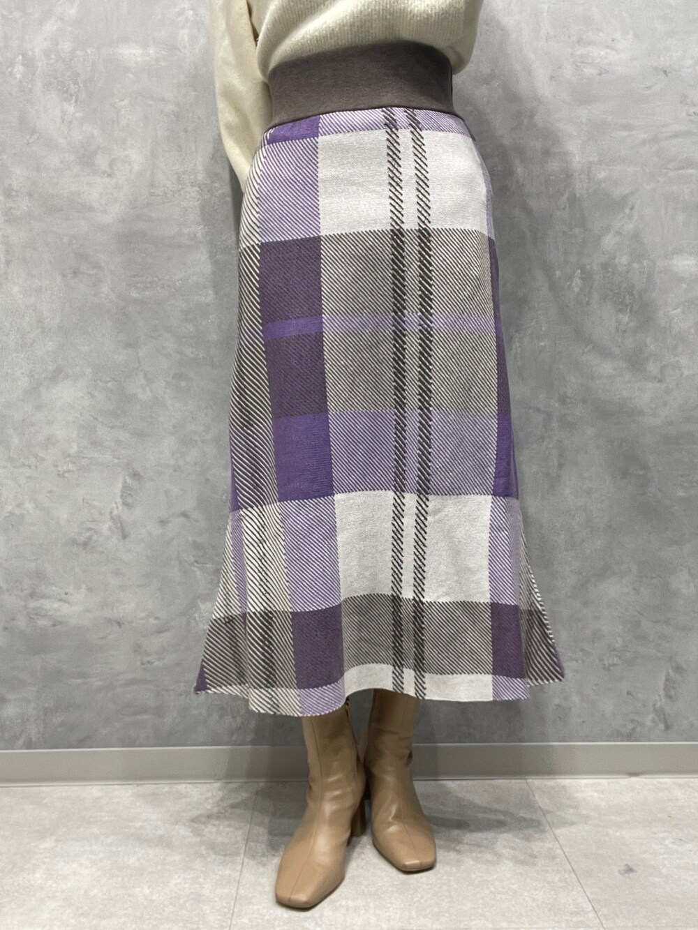 ベージュ系のブーツ、ホワイト系のニット/セーター、パープル系のスカートを着用したレディースの冬コーディネートの7枚目の写真