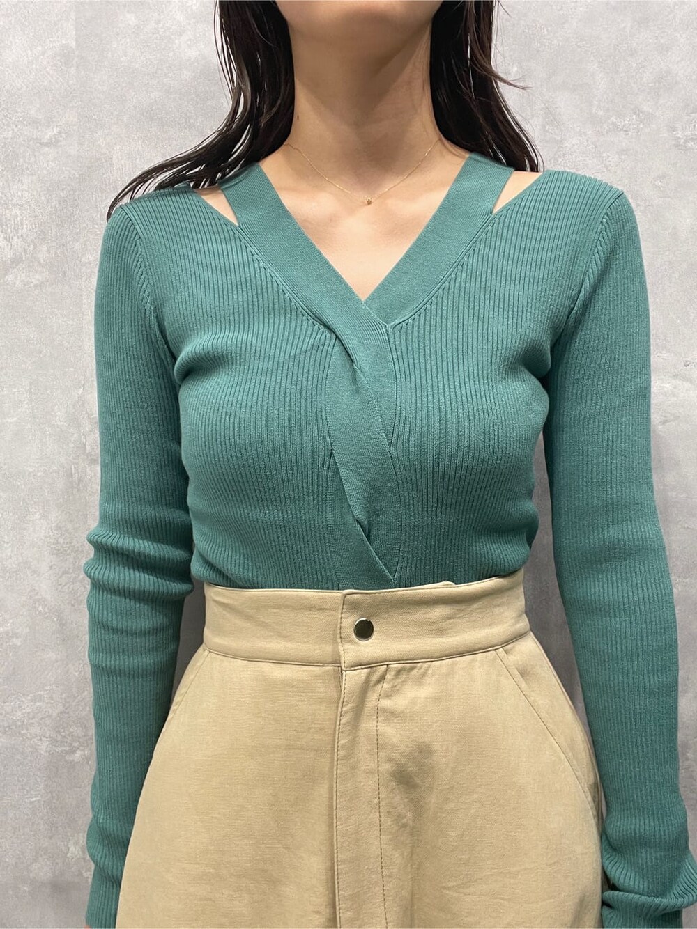 ベージュ系のスカート、ベージュ系のブーツ、グリーン系のニット/セーターを着用したレディースの夏コーディネートの7枚目の写真