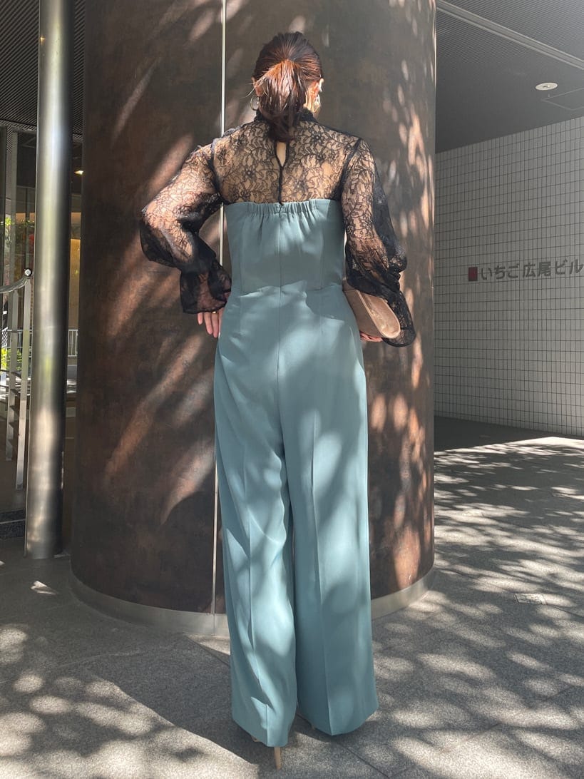 ゴールド系のクラッチバッグ、ゴールド系のパンプス、ブラック系のシャツ/ブラウスを着用したレディースの秋コーディネートの5枚目の写真