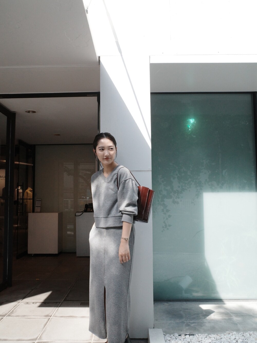 グレー系のスカート、グレー系のスウェット、ブラック系のブーツを着用したレディースの夏コーディネートの2枚目の写真