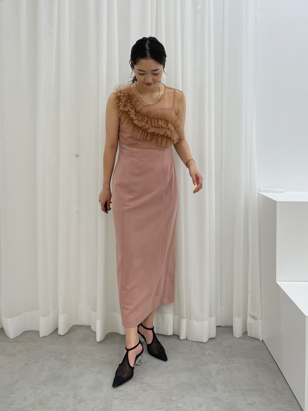 ブラック系のパンプス、ピンク系のドレスを着用したレディースの春コーディネートの2枚目の写真