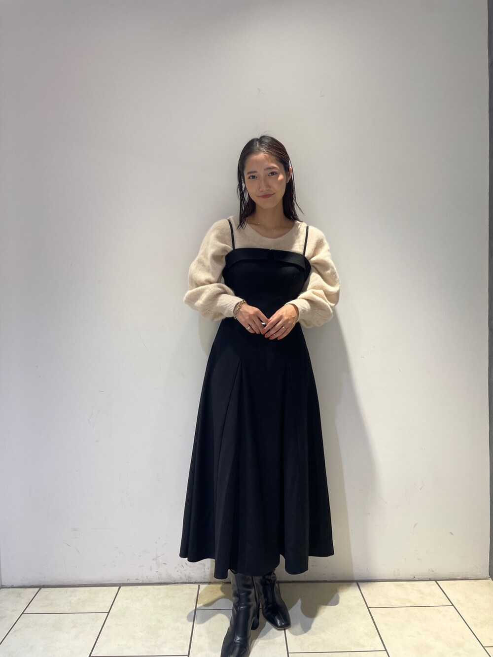 ホワイト系のニット/セーター、ブラック系のワンピース、ブラック系のブーツを着用したレディースの秋コーディネートの3枚目の写真