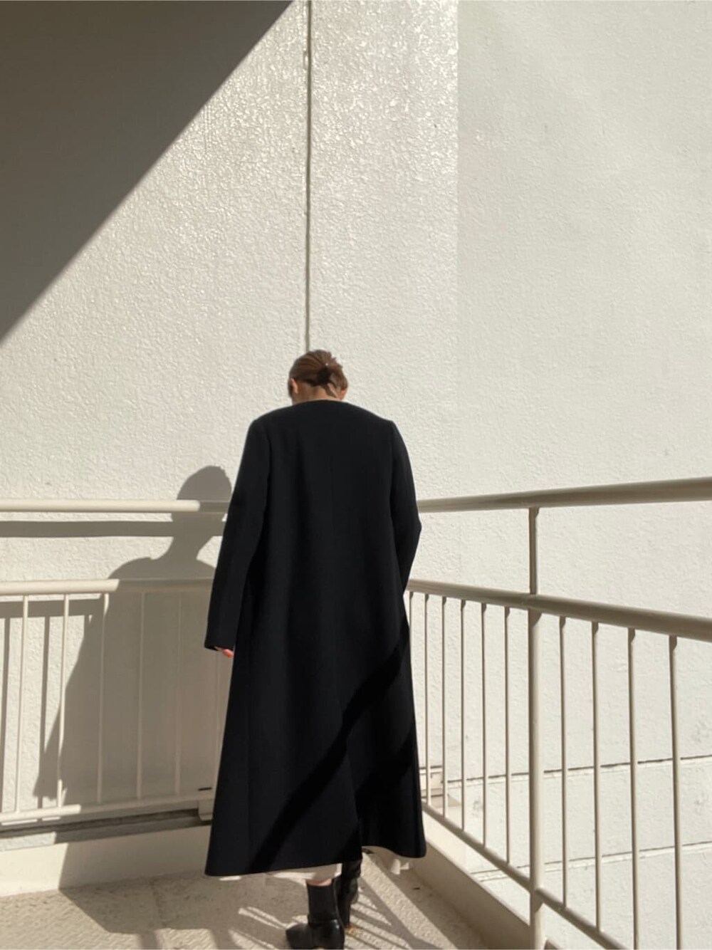 ブラック系のその他シューズ、ブラック系のその他アウター、ホワイト系のワンピースを着用したレディースの冬コーディネートの10枚目の写真