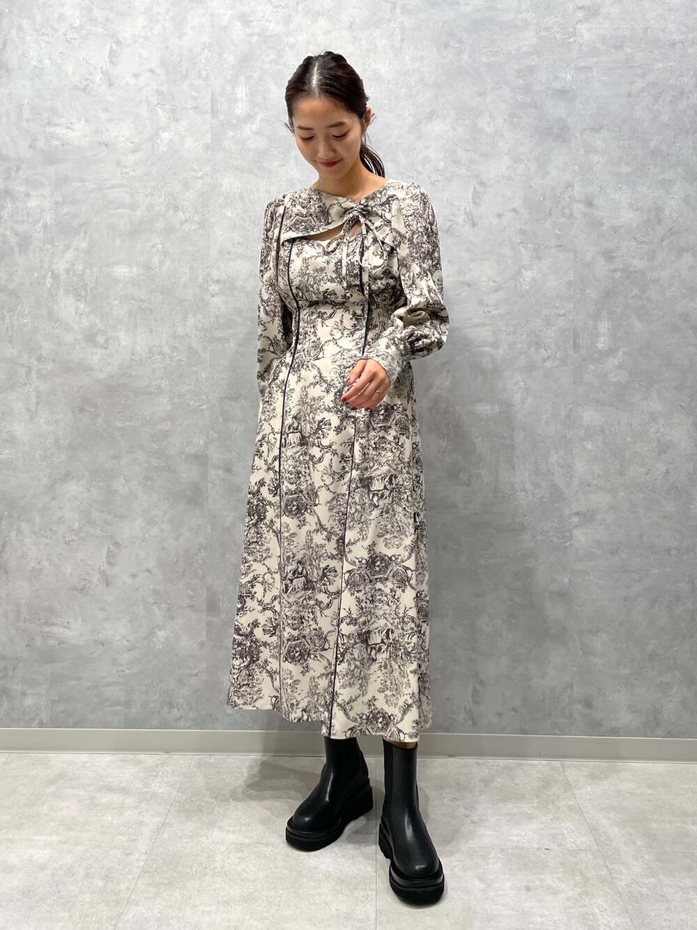 グレー系のカーディガン/ボレロ、ホワイト系のワンピース、ブラック系のブーツを着用したレディースの冬コーディネートの7枚目の写真