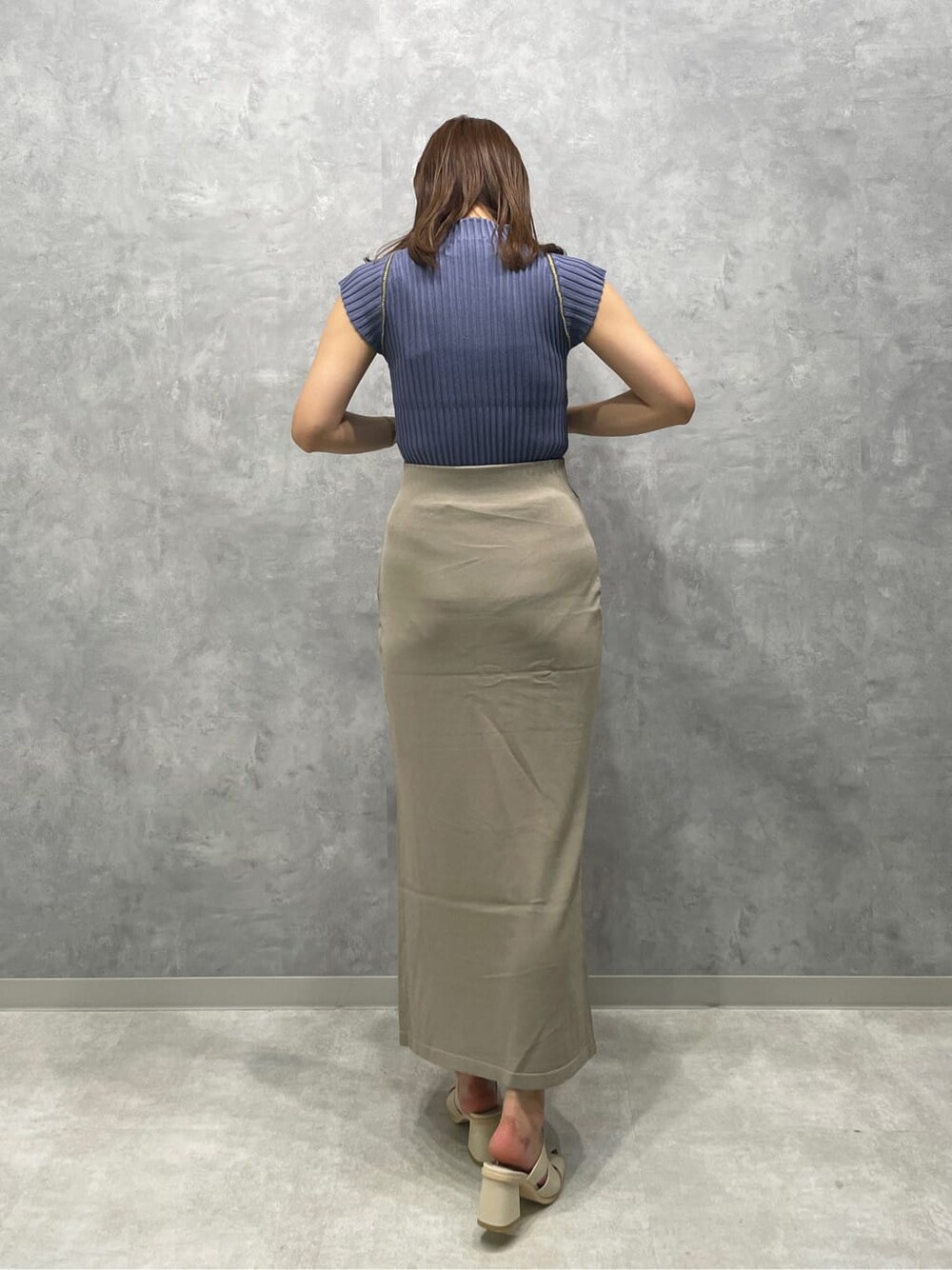 ホワイト系のサンダル、ベージュ系のスカート、ブルー系のニット/セーターを着用したレディースの夏コーディネートの4枚目の写真