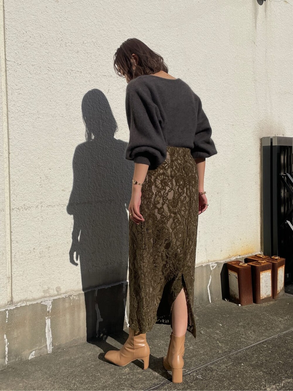 ベージュ系のその他シューズ、ベージュ系のスカート、グレー系のニット/セーターを着用したレディースの冬コーディネートの2枚目の写真