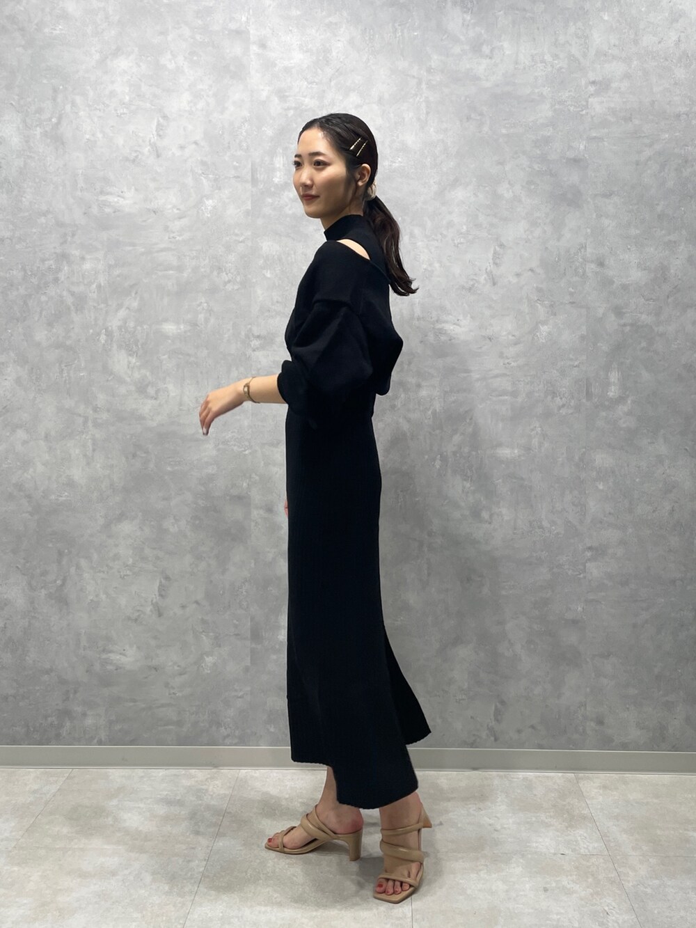 ベージュ系のサンダル、ブラック系のワンピースを着用したレディースの冬コーディネートの3枚目の写真